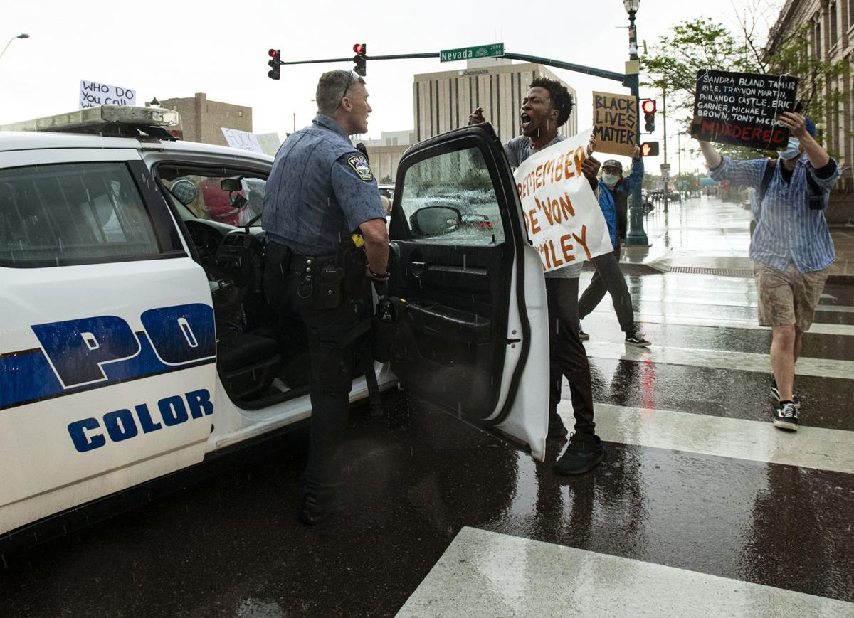 A protester confronts a Colorado Springs police officer about the death of De’Von Bailey, 19, who was shot and killed by police in 2019, during a protest calling for justice in the death of George Floyd and police brutality in downtown Colorado Springs, Colorado. May 30, 2020. Photo Credit: Chancey Bush, The Gazette