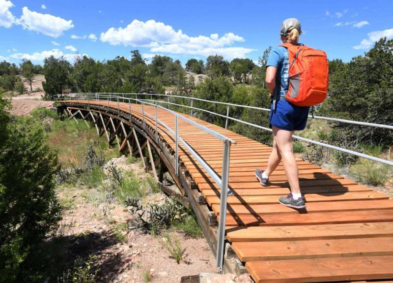 Ashlee Sack of Fremont Adventure Recreation crosses an old railroad bridge with brand new boards. This is part of a new effort to bring more trails to the area.Photo Credit: Jerilee Bennett, The Gazette.