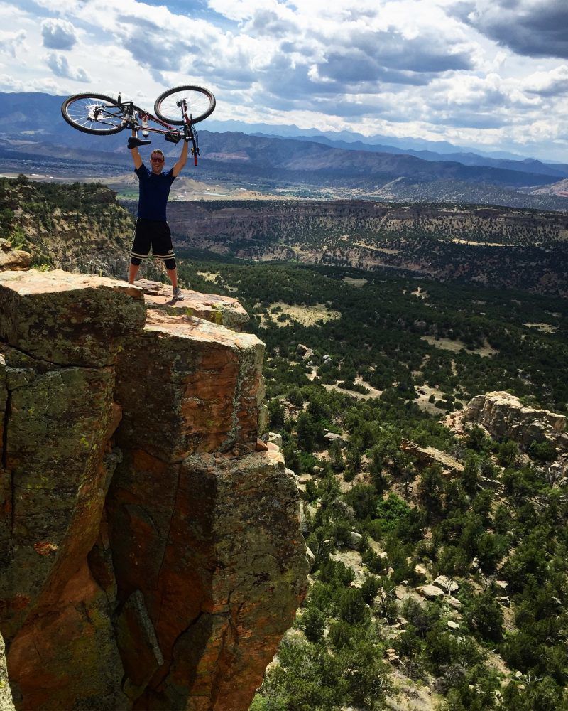 Spencer McKee hoists his bike high in the air at the perfect photo opt.Photo Credit: Jeff Gratzmiller.