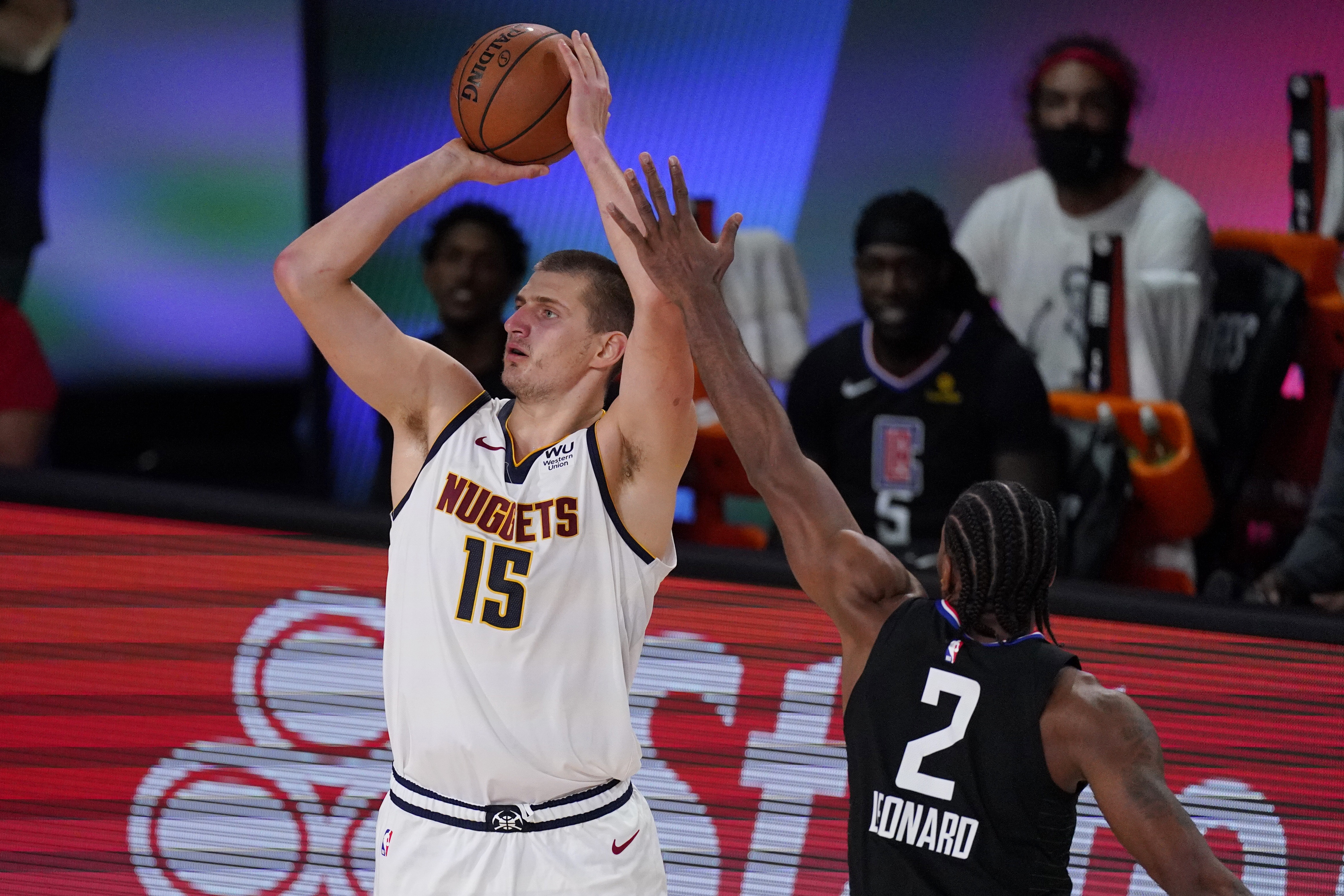 Denver Nuggets' Nikola Jokic (15) shoots in front of Los Angeles Clippers' Kawhi Leonard (2) in the second half of an NBA conference semifinal playoff basketball game Thursday, Sept 3, 2020, in Lake Buena Vista Fla. (AP Photo/Mark J. Terrill) (Mark J. Terrill)