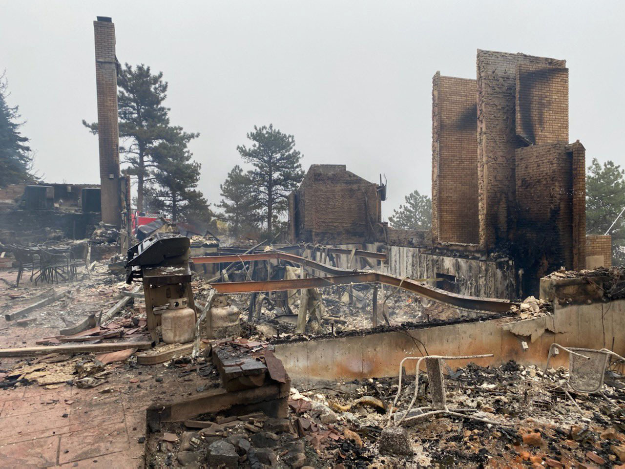 This photo, posted on Twitter Sunday by Boulder County woman Courtney Walsh, shows her home burned to its foundation, leaving part of a brick facade and pieces of twisted steel jutting out of charred rubble.