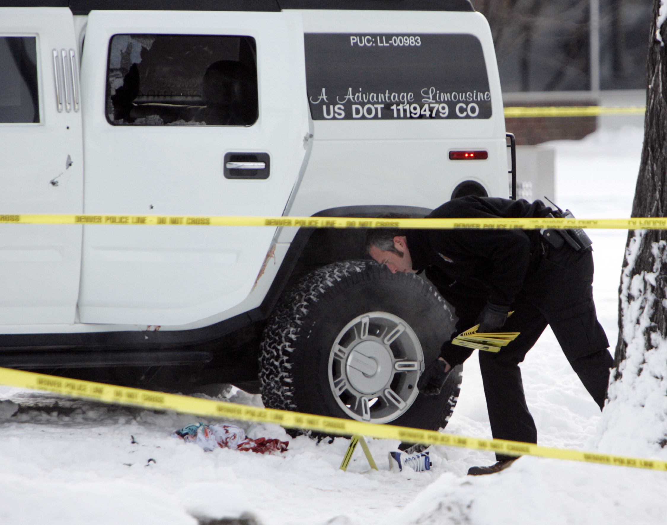An investigator with the Denver Police Department places evidence markers next to a Hummer limousine in which Denver Broncos cornerback Darrent Williams was shot and killed while riding inside Jan. 1, 2007, in Denver. It has been more than 13 years since 24-year-old Williams died in the early hours of New Year’s Day after gunfire following a confrontation between Broncos players and gang members at a nightclub. (the associated press file)