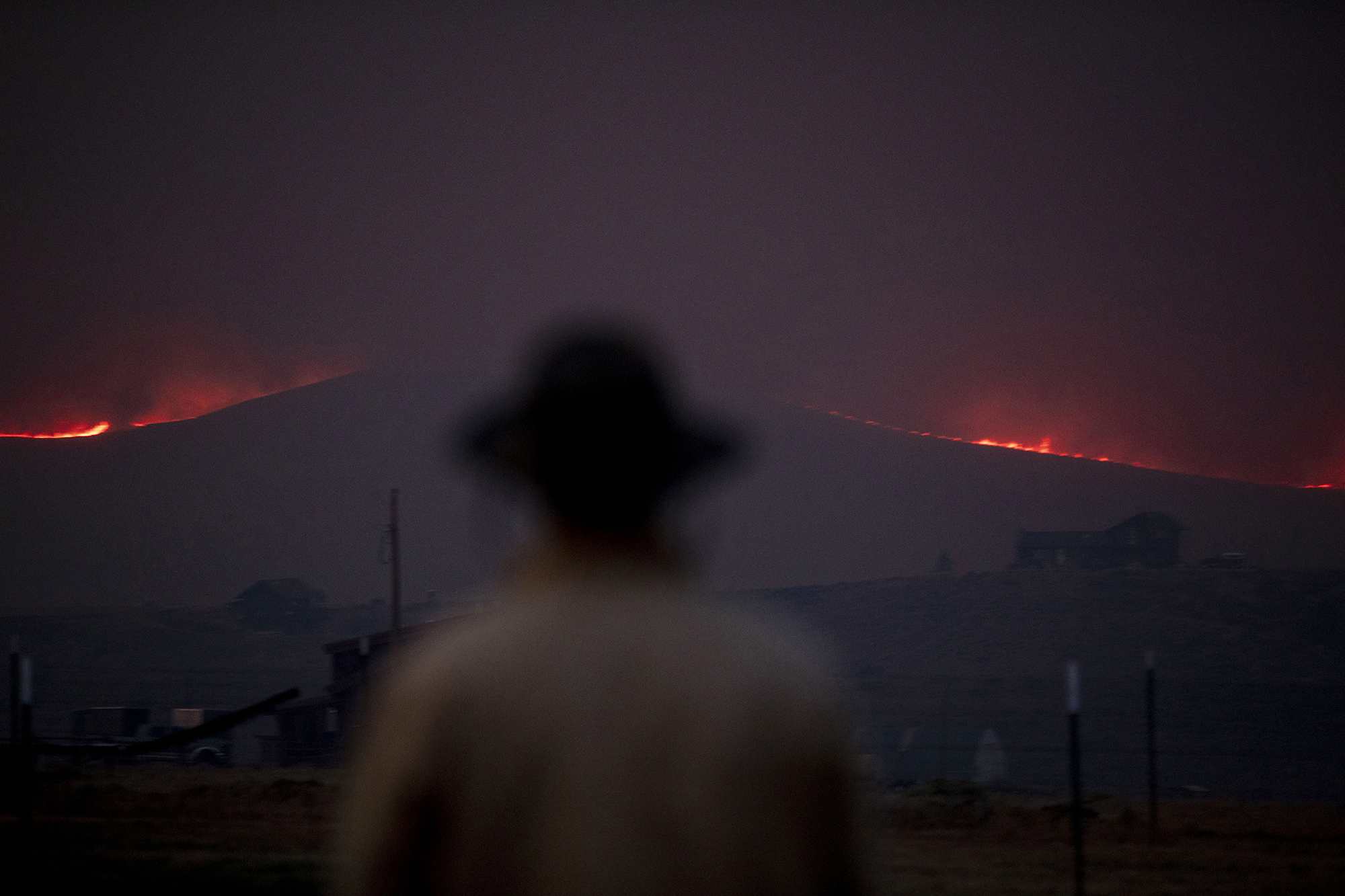 Asa Holley watches the East Troublesome fire burn along the ridge across from his family farm, Sisu Farms in Granby, in Grand County on Thursday, Oct. 22, 2020. The East Troublesome fire has grown to be the second-largest wildfire in Colorado history. (Chancey Bush/ The Gazette) (Chancey Bush The Gazette)