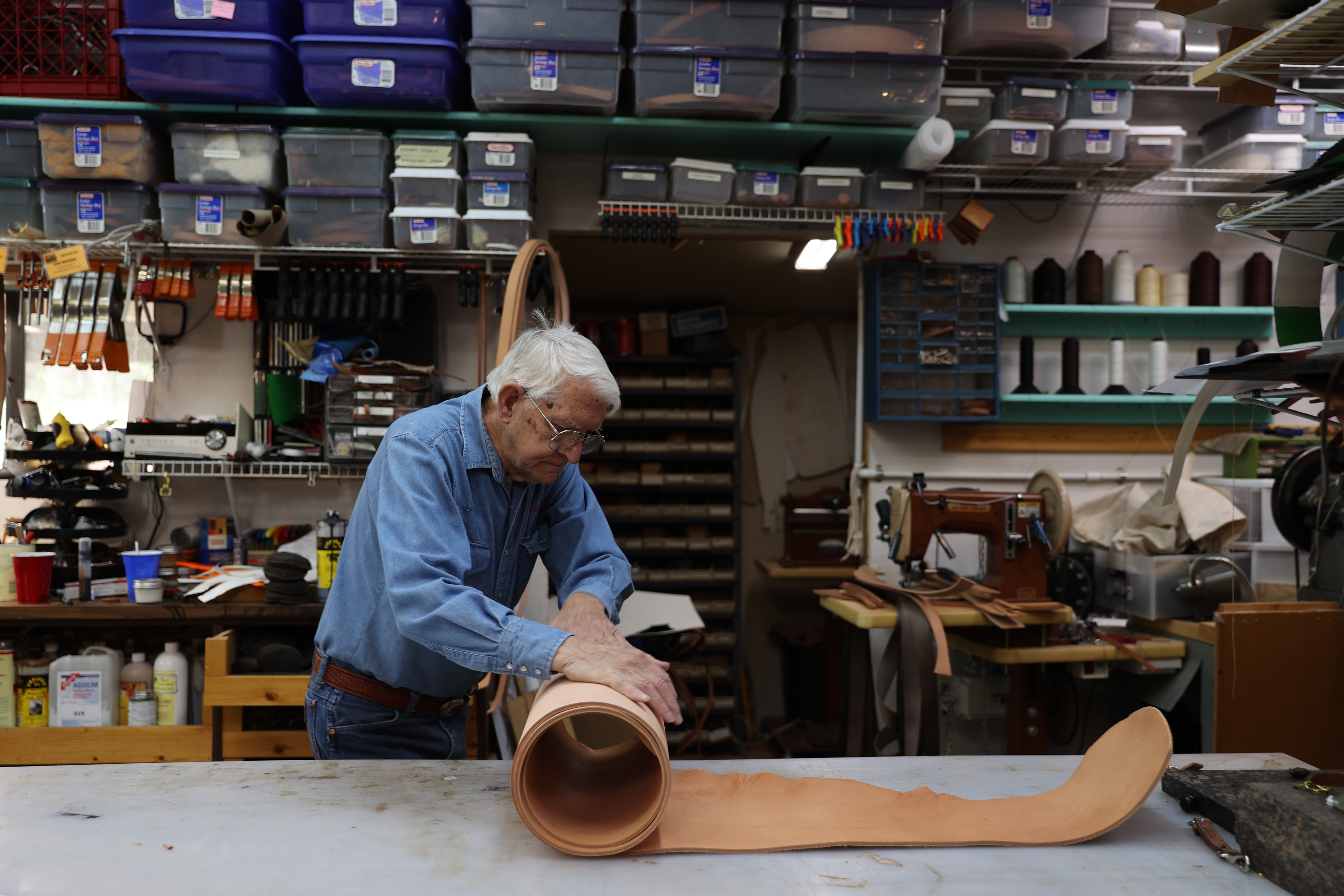 Bob Brenner rolls up a large section of leather while working in his saddle shop in Black Forest. Brenner owns Pikes Peak Saddlery and has been restoring and making custom saddles since the 1970s. (Forrest Czarnecki, the gazette)