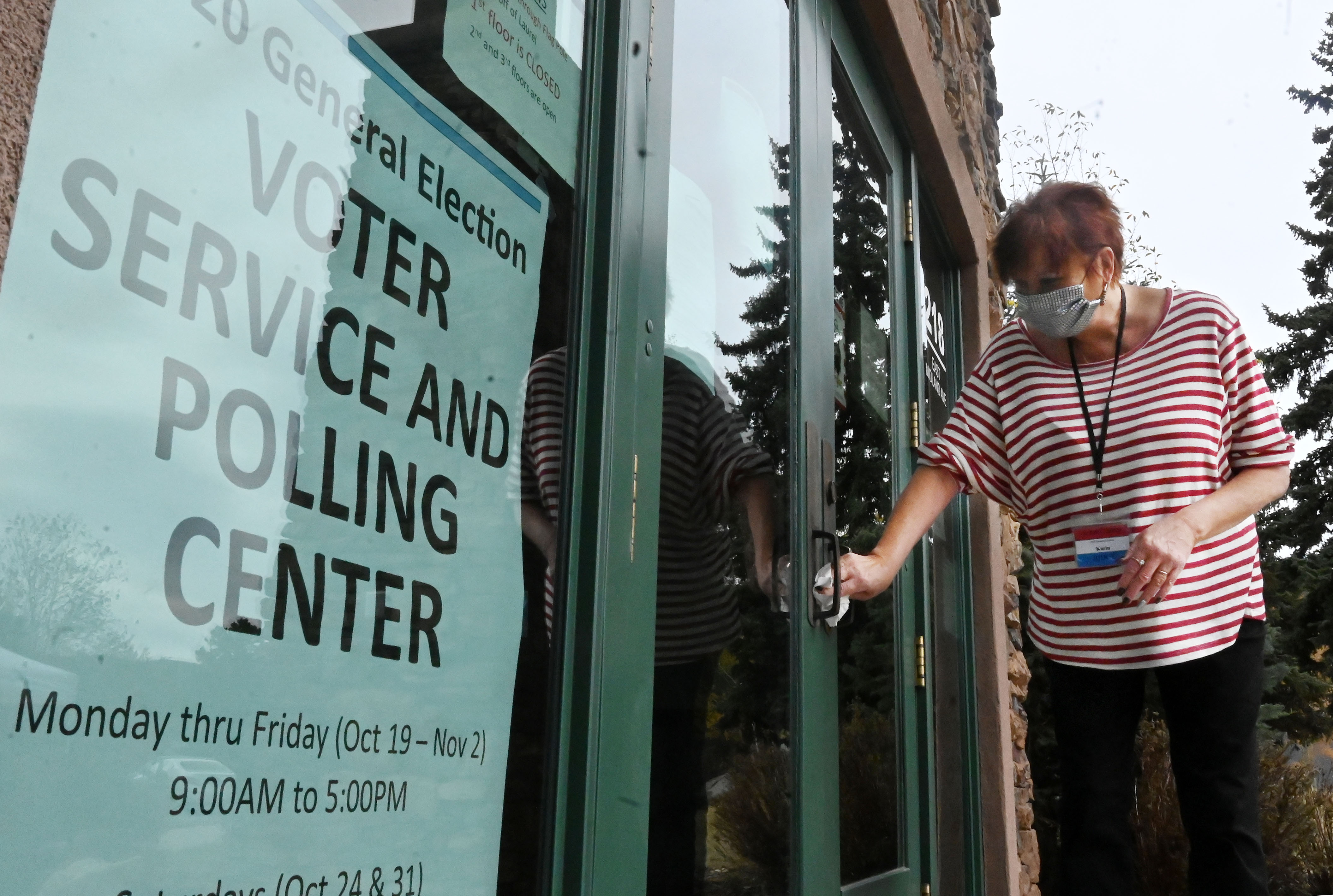 Election judge Karin Bugatti has been making sure that the door handles stay sanitized for those coming to vote early in Woodland Park last week, 2020. Early in-person voting started in Teller County at the Woodland Park Library. (Photo by Jerilee Bennett, The Gazette) (JERILEE BENNETT, THE GAZETTE)