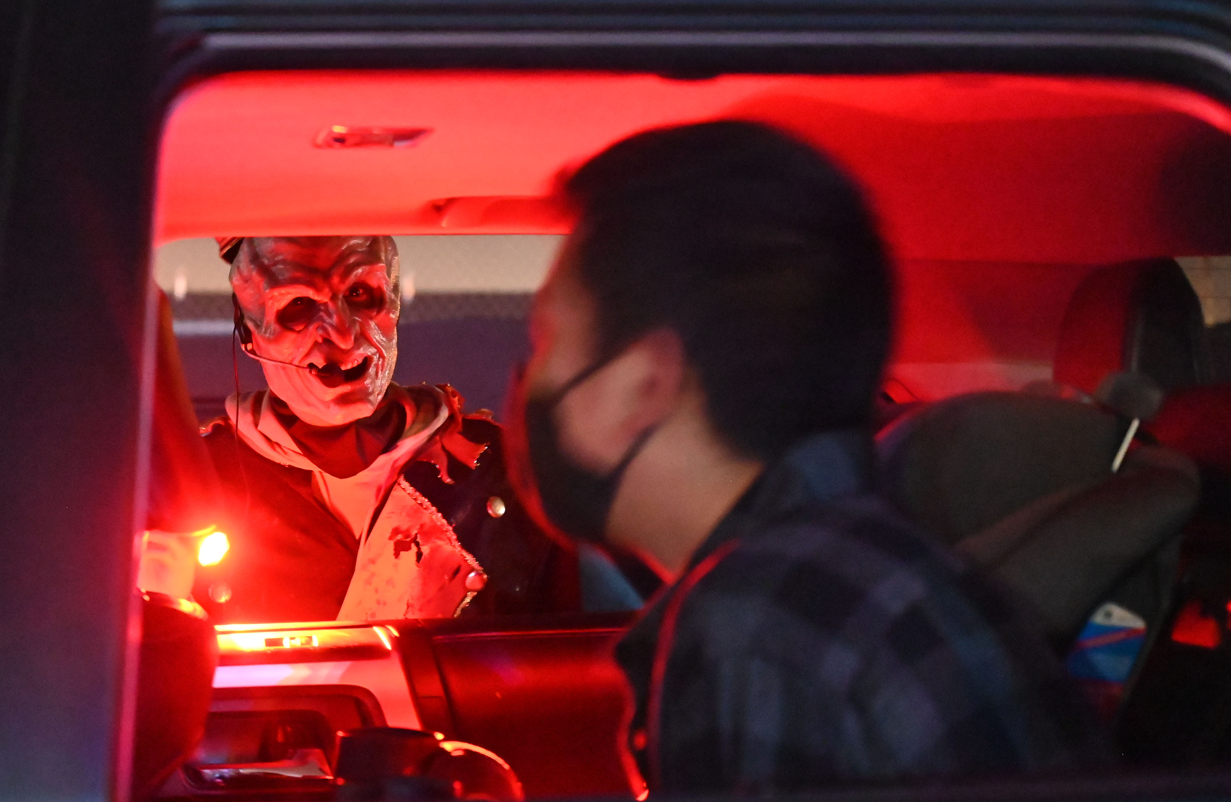 City of the Dead Drive-In is a way for visitors to get a haunted house type experience, without leaving the healthy comfort of their vehicle. Before the show starts, a zombie usher pays a visit to one of the customers on Wednesday, Oct. 21, 2020. (Photo by Jerilee Bennett, The Gazette) (JERILEE BENNETT THE GAZETTE)