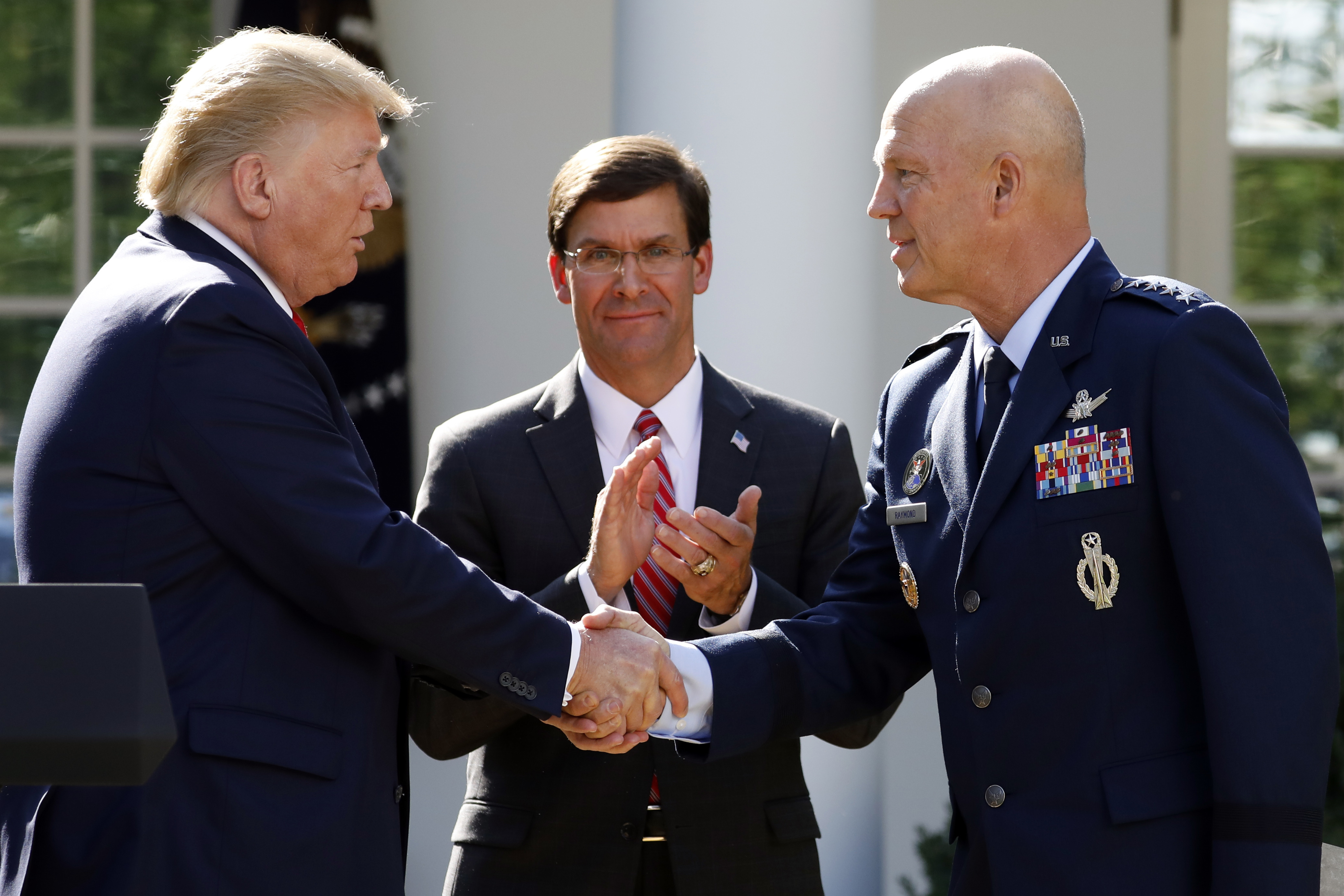 President Donald Trump shakes hands with Gen. Jay Raymond, commander of Air Force Space Command, as Defense Secretary Mark Esper applauds during the announcement of establishment of the U.S. Space Command last August. (The Associated Press)