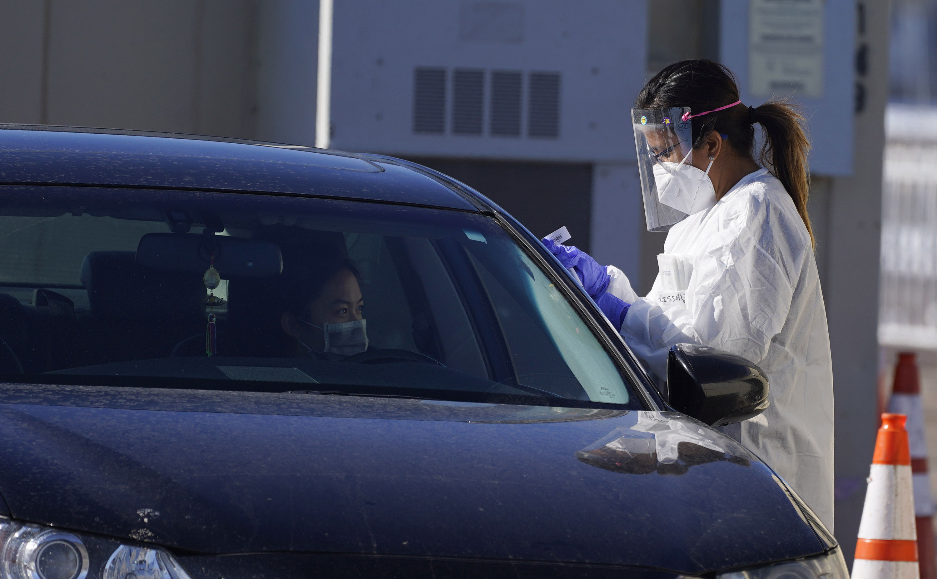 A motorist waits for a swab test this week at a drive-in COVID-19 testing site in Federal Heights. Denver will enforce tighter restrictions for restaurants, retail and offices, reducing maximum capacity from 50% to 25% amid a rise in coronavirus cases in the state in the past month. (The Associated Press)