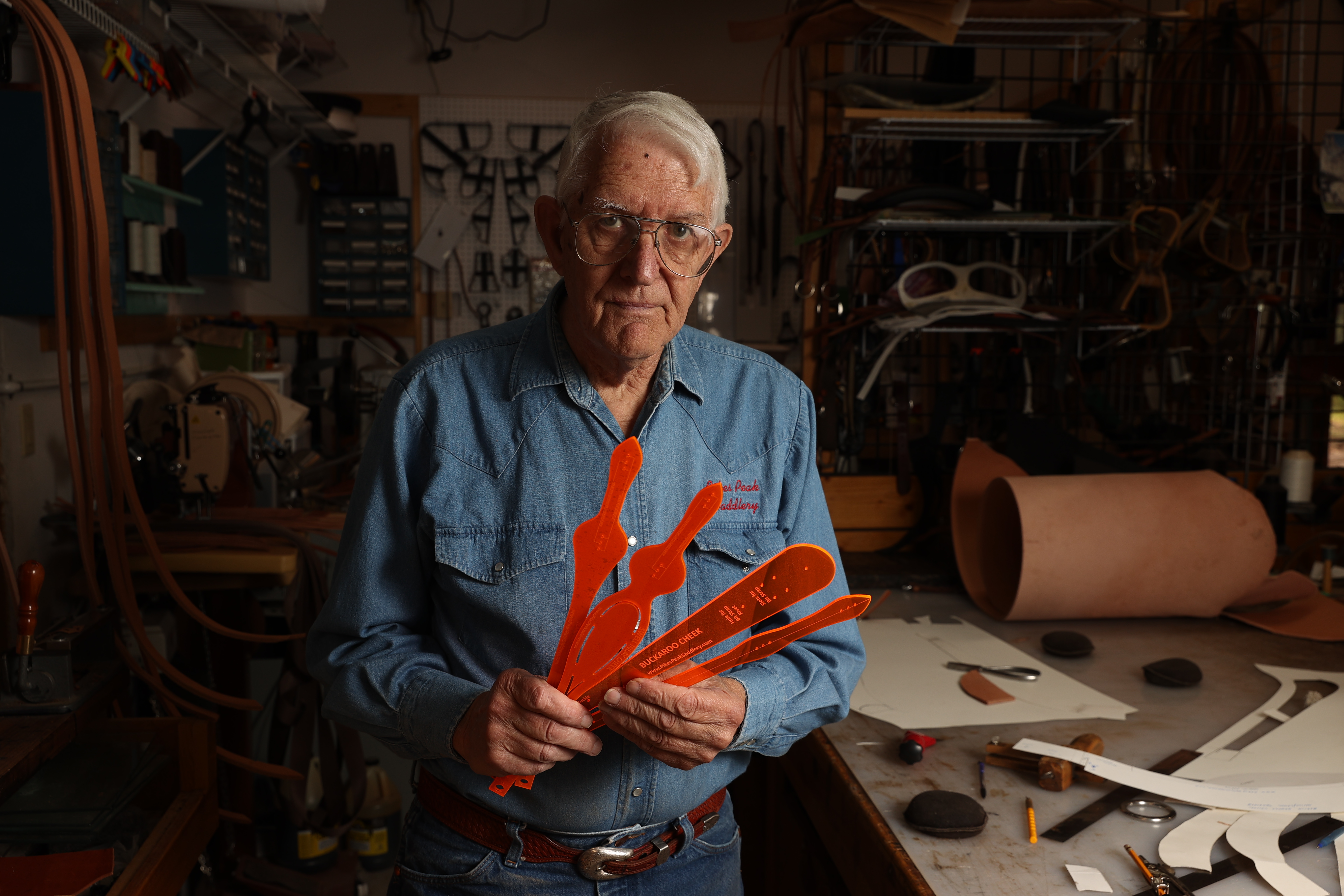 Bob Brenner holds up some tracing patterns for breast collars, head stalls and other tack in his shop in Black Forest. Brenner recently got his career’s 963rd order, and he fully intends to see his 1,000th saddle made. (photos by Forrest Czarnecki, the gazette)