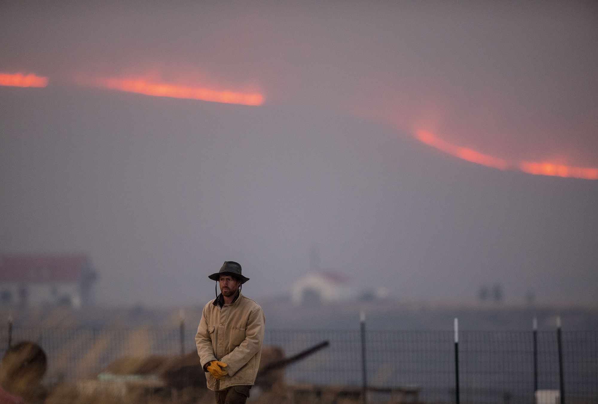 Asa Holley watches the East Troublesome fire burn along the ridge across from his family farm, Sisu Farms in Granby, in Grand County on Thursday, Oct. 22, 2020. The East Troublesome fire has grown to be the second-largest wildfire in Colorado history. (Chancey Bush/ The Gazette) (Chancey Bush The Gazette)