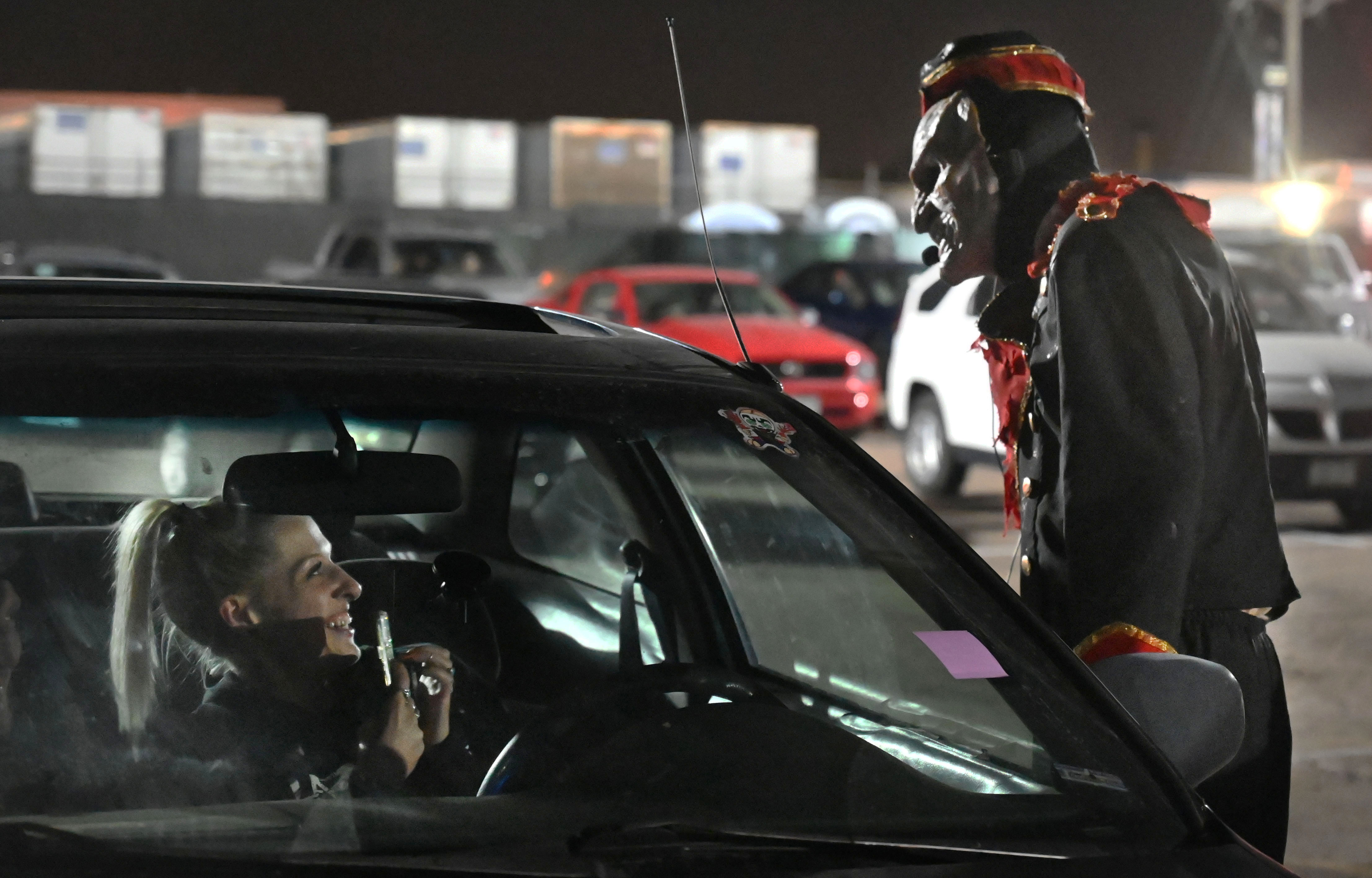 City of the Dead Drive-In is a way for visitors to get a haunted house type experience, without leaving the healthy comfort of their vehicle. Before the show starts, a zombie usher pays a visit to to Rachel Kordus on Wednesday, Oct. 21, 2020. (Photo by Jerilee Bennett, The Gazette) (JERILEE BENNETT, THE GAZETTE)