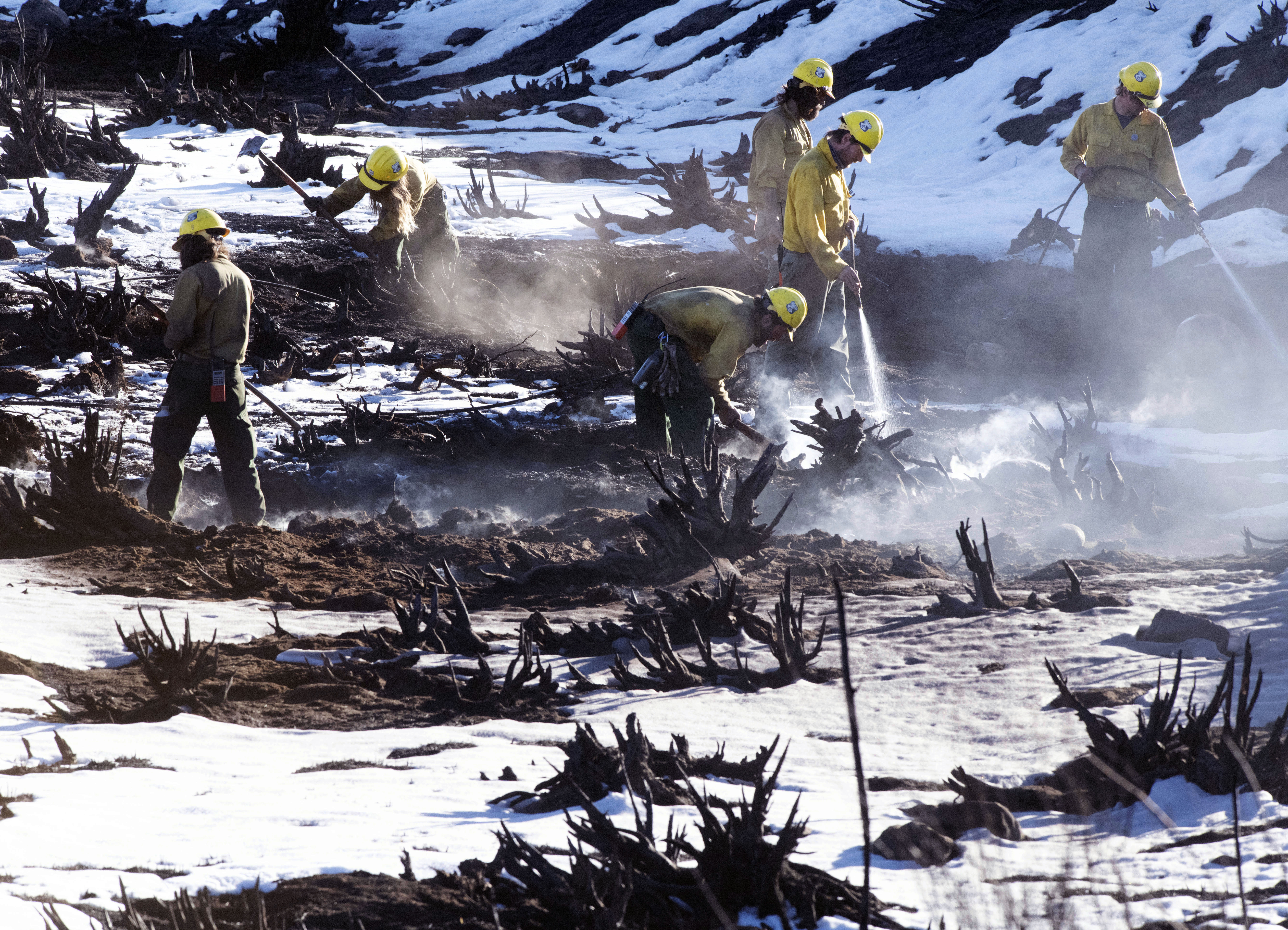 Although the nearly 8 inches of snow that fell near Grand Lake, Colorado, was able to substantially slow down the East Troublesome Fire the fire can still smolder underneath the snow. Firefighters from Oregon knock down smoldering stumps near Grand Lake on Sunday, Nov. 1, 2020. (Photo by Jerilee Bennett, The Gazette) (JERILEE BENNETT, THE GAZETTE)