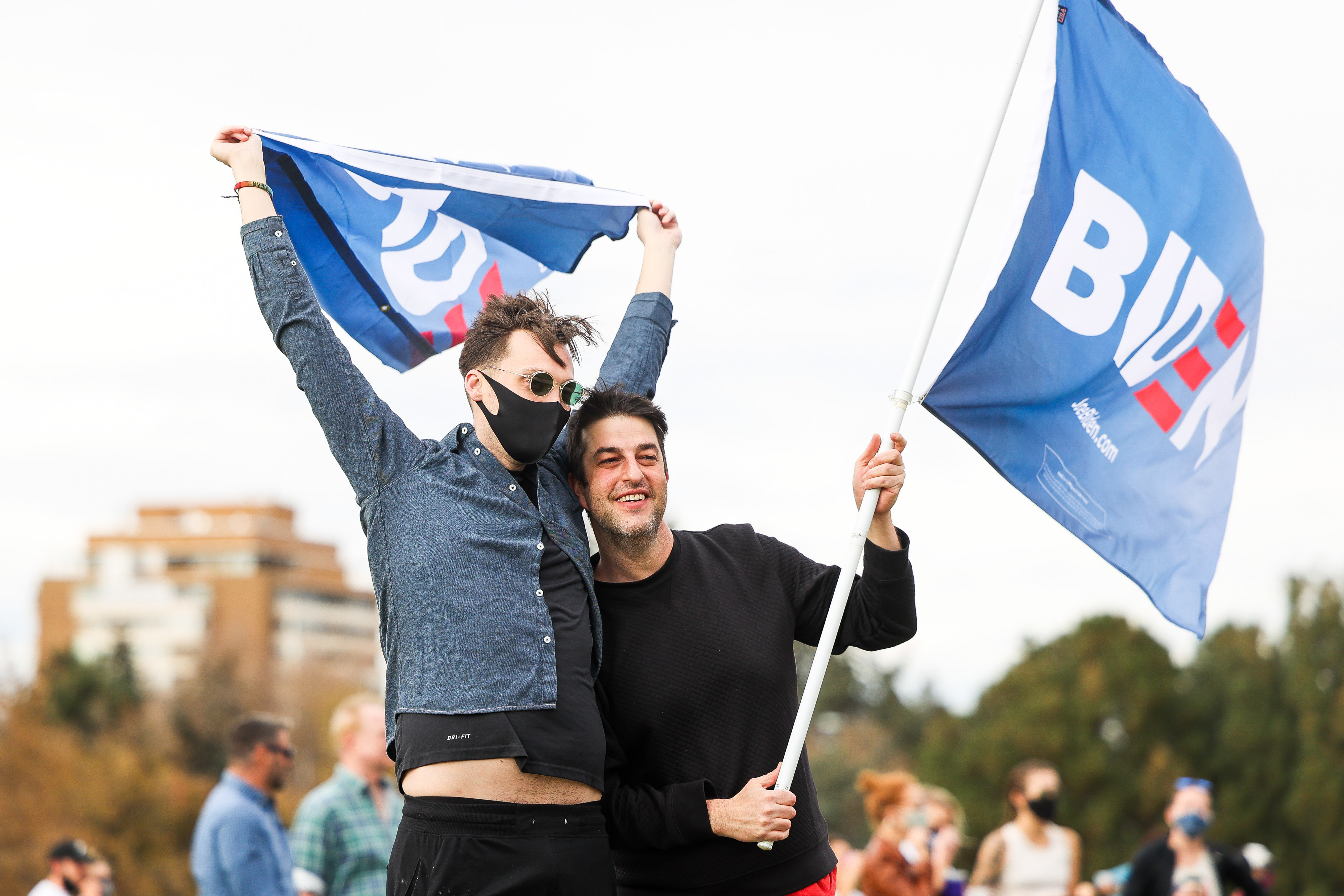 Richard Buchanan, left, and Yves Murad wave Biden flags as people celebrate the announcement that Joe Biden was elected as the next president of the United States according to multiple news sources Saturday, Nov. 7, 2020 at Cheeseman Park in Denver. (Michael Ciaglo/Special to The Denver Gazette) (Michael Ciaglo/Special to The De)