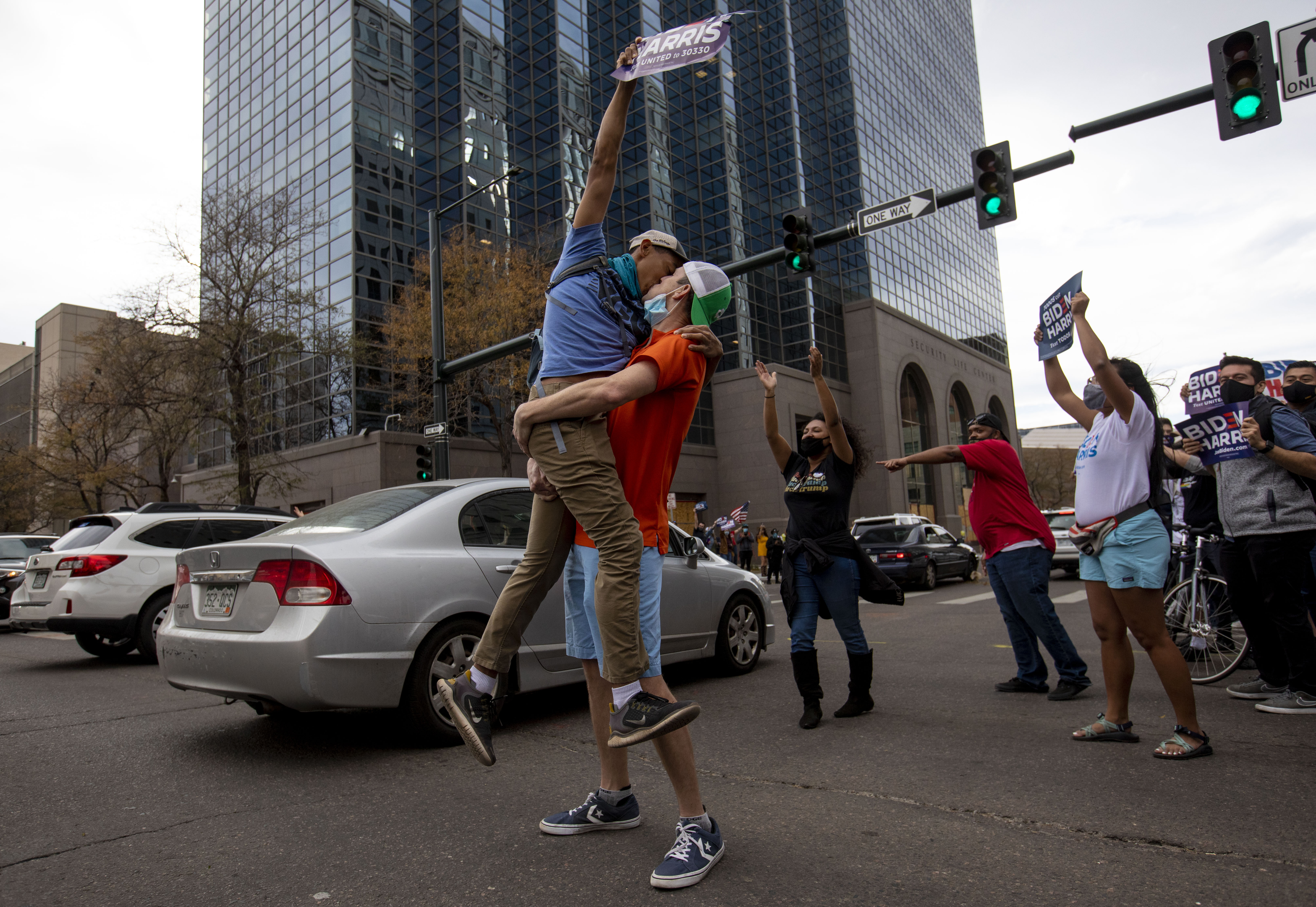Brent Walker picks up his boyfriend Ezra Comesario and kisses him during a celebration of the victory of Democratic candidate Joseph Biden at the intersection of Lincoln Street and 13th Avenue in downtown Denver, Colo., on Saturday, Nov. 7, 2020. (Chancey Bush/ The Gazette) (Chancey Bush The Gazette)