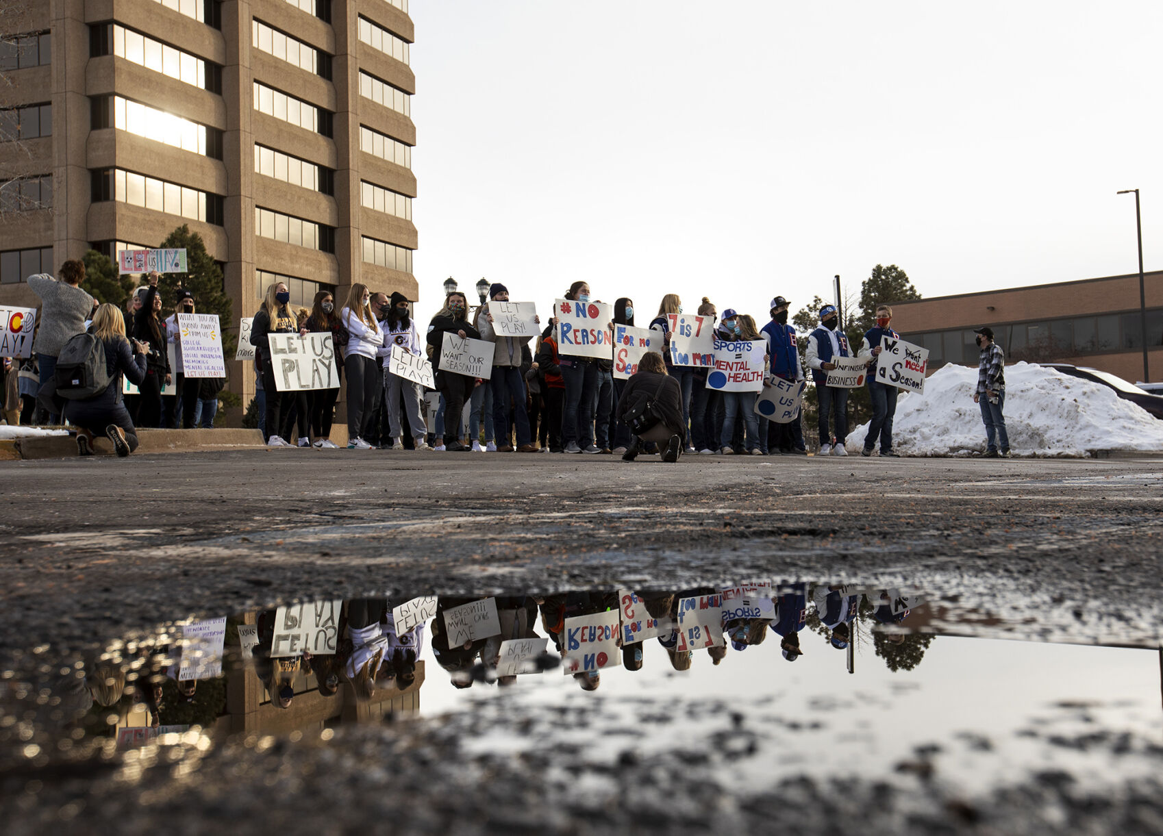 Students gather Thursday outside the office of the Colorado Department of Public Health and Environment in Glendale. Around 70 students, parents and coaches participated in response to the postponement of high school winter sports. (Chancey Bush, The Gazette)