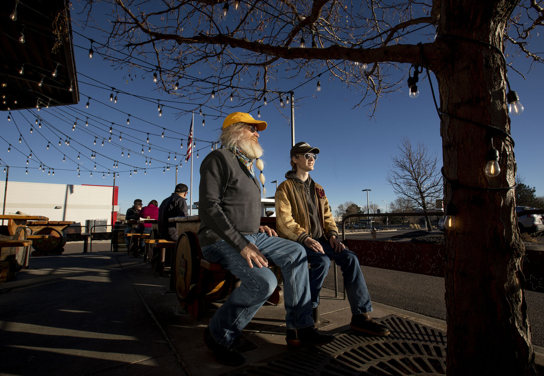 Regular John Katona enjoys the sunny weather with his son Konnor Katona, 15, outside on the patio at Trinity Brewing Company in Colorado Springs on Dec. 22, 2020. Matt Dettmann is Trinity Brewing Company's new owner after the award-winning brewery was sold by Jason Yester in July 2020. Chancey Bush/ The Gazette) (Chancey Bush/ The Gazette)