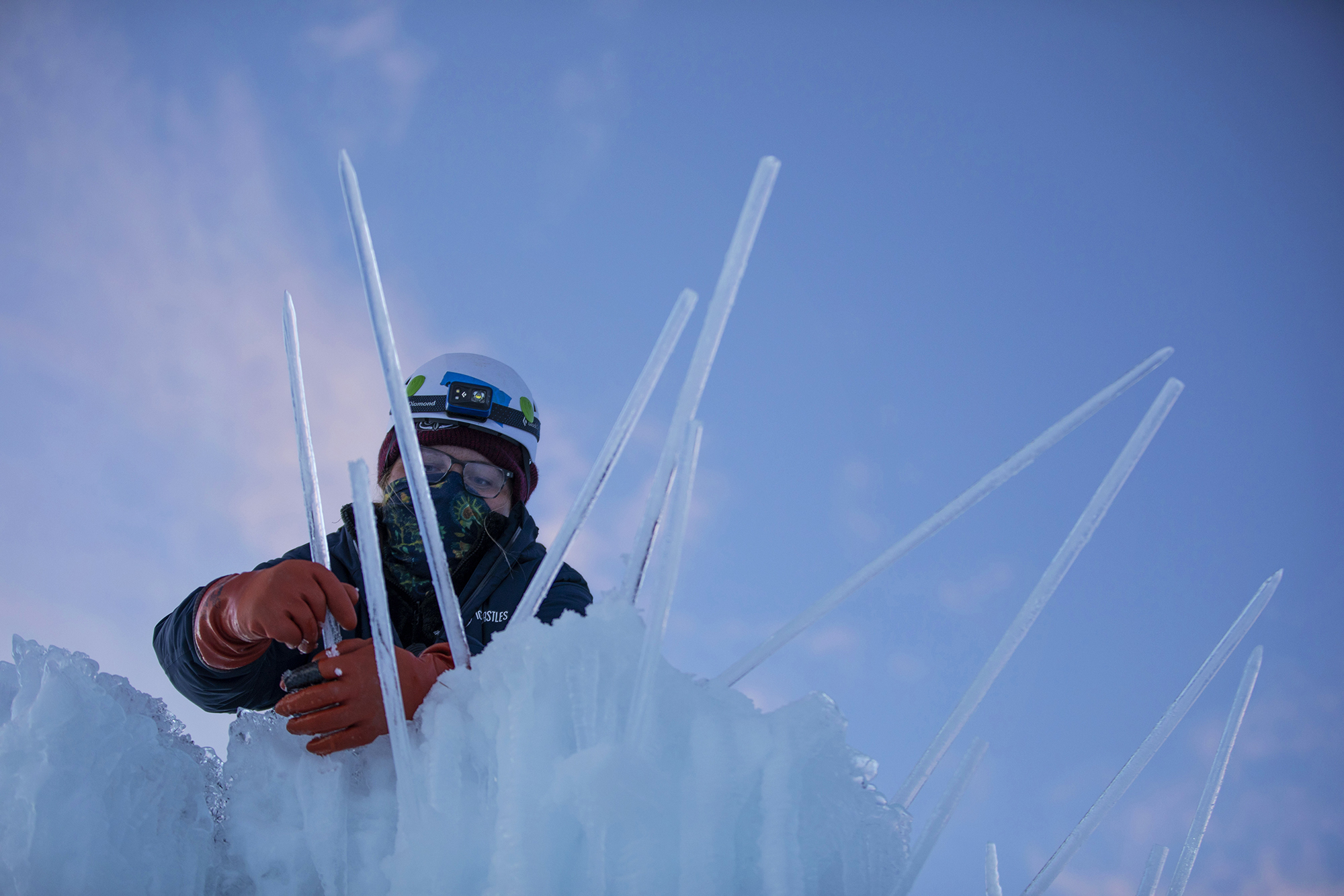 Maria Franks places icicles onto of sculptures inside the Dillon Ice Castles in Dillon, Colo., on Wednesday, Dec. 9, 2020. Ice artisans spend around six weeks placing up to 10,000 icicles each day to create the life-size winter fairytale built entirely from ice.The Ice Castles return for the fourth year with limited capacity due to the COVID-19 pandemic. The Ice Castles are expected to open around Christmas. (Chancey Bush/ The Gazette) (Chancey Bush/ The Gazette)