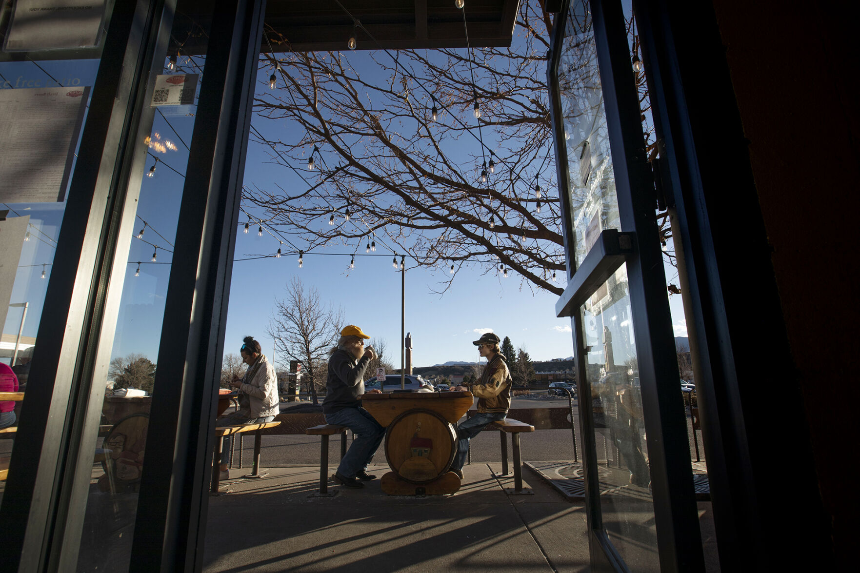Regular John Katona enjoys the sunny weather with his son Konnor Katona, 15, outside on the patio at Trinity Brewing Company in Colorado Springs on Dec. 22, 2020. Matt Dettmann is Trinity Brewing Company's new owner after the award-winning brewery was sold by Jason Yester in July 2020. Chancey Bush/ The Gazette) (Chancey Bush/ The Gazette)
