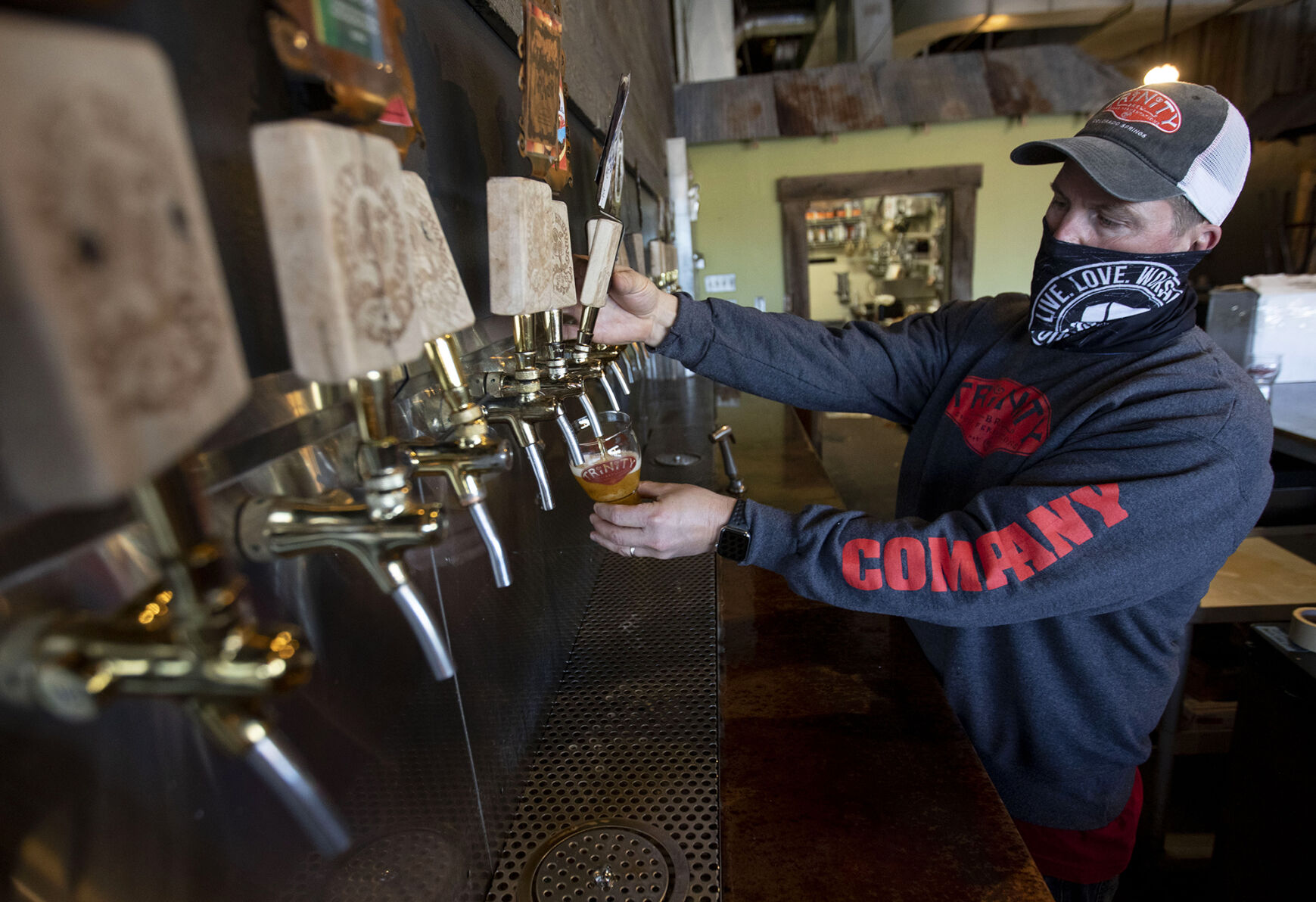Matt Dettmann, new owner of Trinity Brewing Company, pours a glass of Space Force IPA at the brewery located at 1466 Garden of the Gods Road in Colorado Springs on Dec. 22, 2020. (Chancey Bush/ The Gazette) (Chancey Bush/ The Gazette)