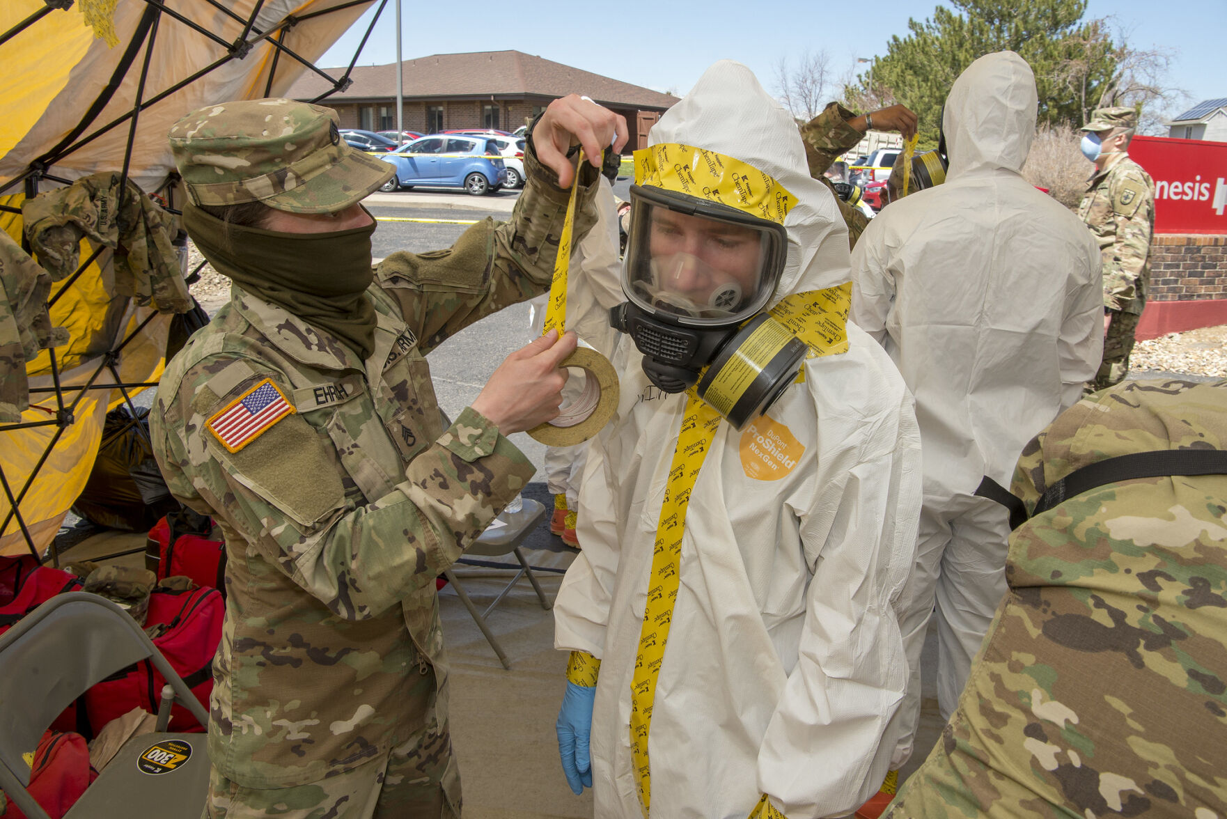 U.S. Army Staff Sgt. Ariella Ehrlich with the Colorado National Guard's 220th Military Police Company places tape on personal protective equipment on Sgt. Richard King, 3650th Support Maintenance Company, as they prepare to perform testing residents of a local nursing home for COVID-19 in Adams County in April. ((U.S. Air National Guard photo by Senior Master Sgt. John Rohrer))