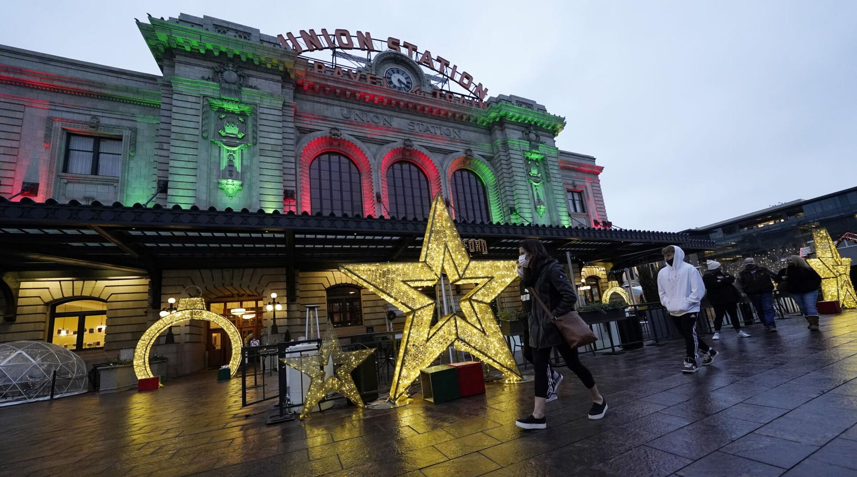 Pedestrians wear masks while shopping amid the holiday lights by Union Station late Monday, Dec. 28, 2020, in downtown Denver. Photo courtesy of David Zalubowski, The Associated Press.