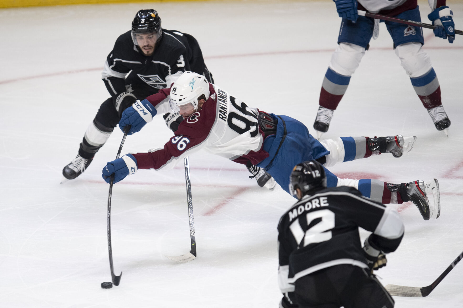 Colorado Avalanche right wing Mikko Rantanen, center, shoots over a reach by Los Angeles Kings defenseman Matt Roy, top, during the second period of an NHL hockey game Tuesday, Jan. 19, 2021 in Los Angeles. (AP Photo/Kyusung Gong) (Kyusung Gong)