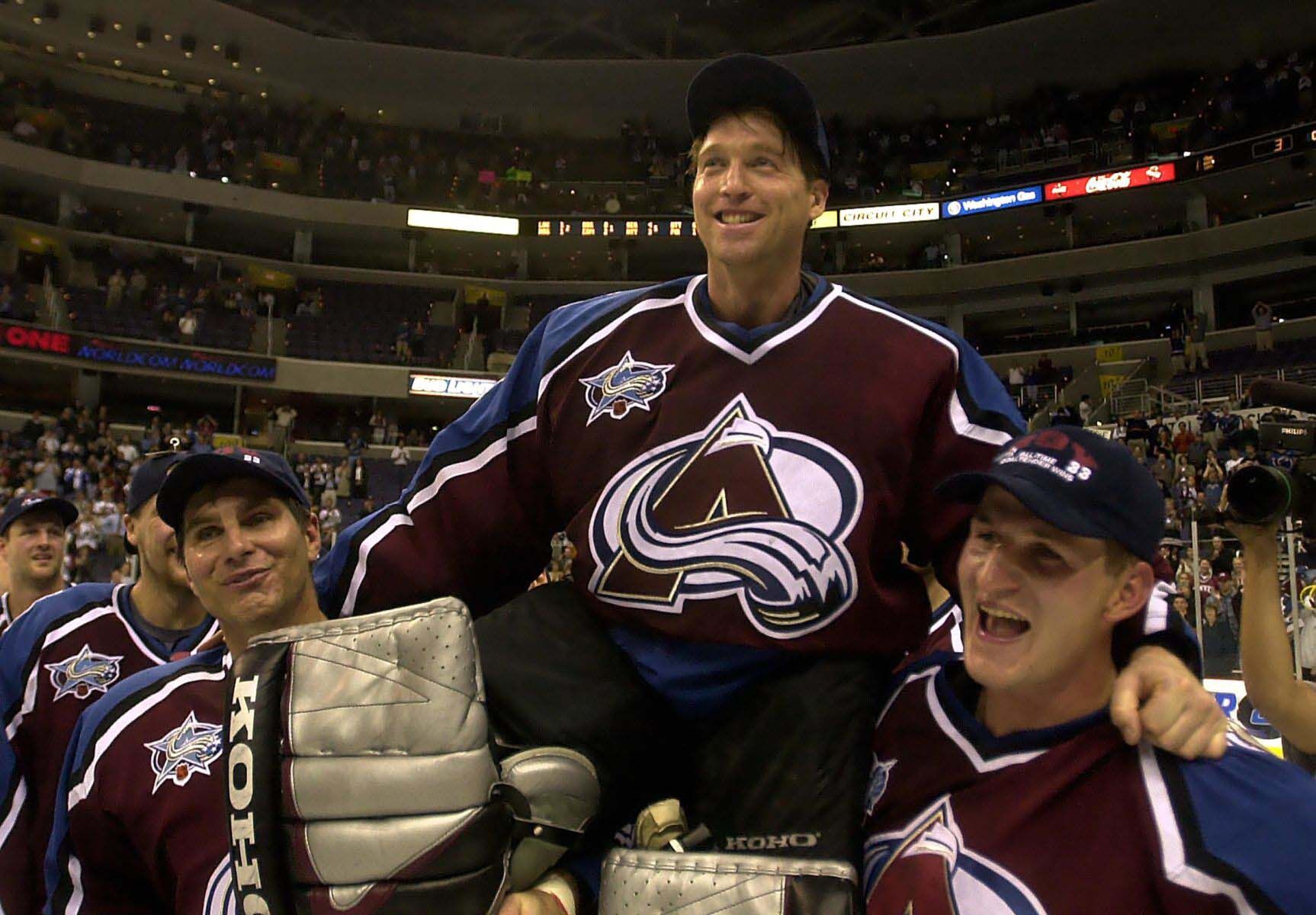 Avalanche goalie Patrick Roy is carried off the ice on the shoulders of teamates Ray Bourque, left, and Adam Foote after he became the winningest goalie in NHL history. (Mark Reis)