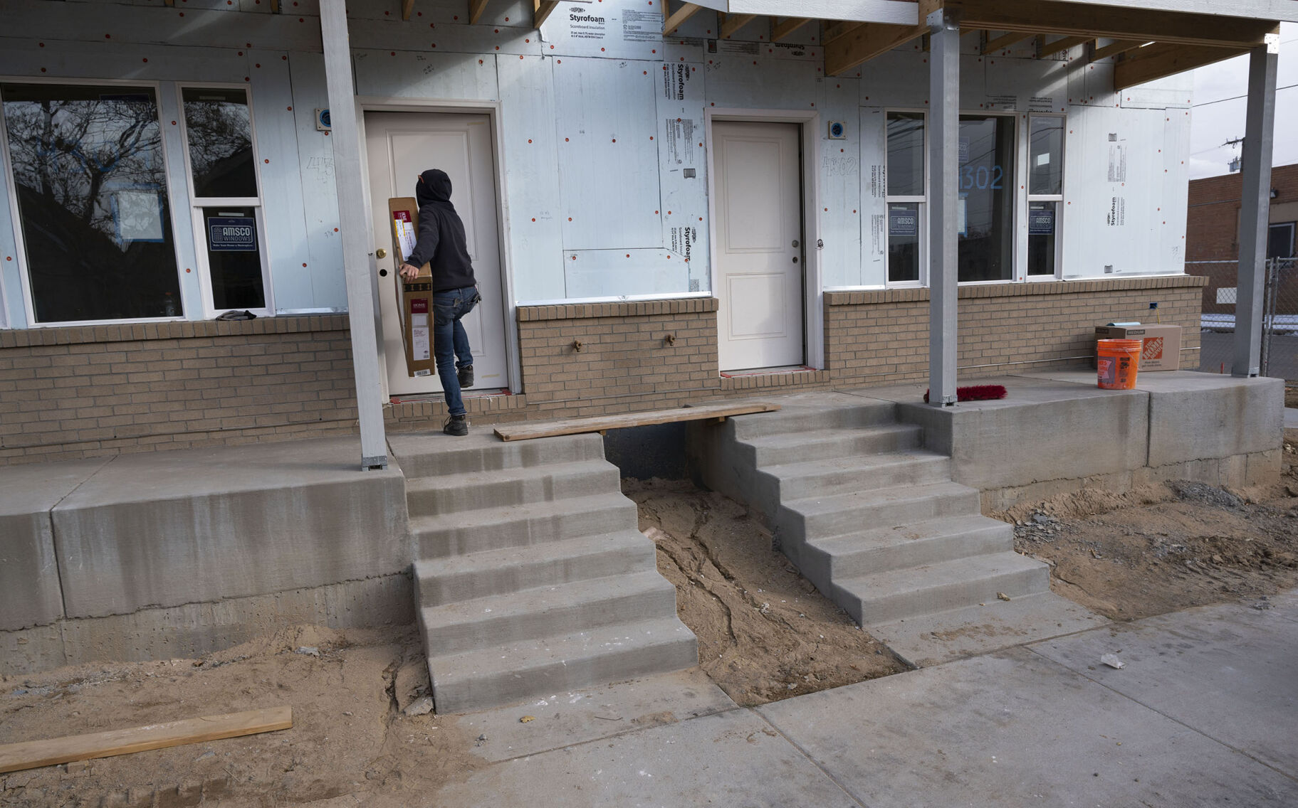 A volunteer brings supplies into one of the 32 units of a Habitat for Humanity of Metro Denver project on Columbine Street in the Globeville neighborhood of Denver in December. (Christian Murdock, The Gazette)