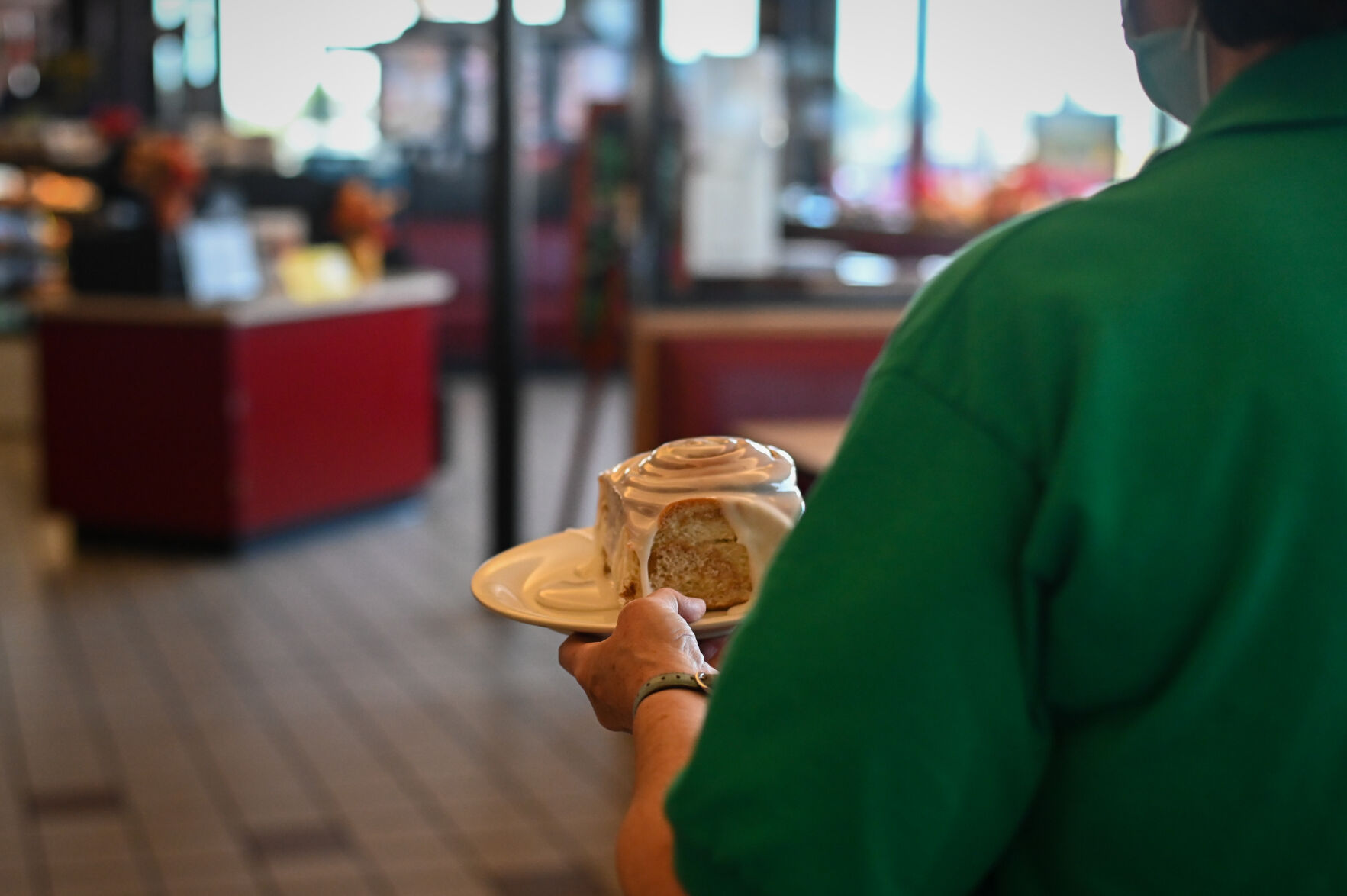 Maria Mendoza brings Johnson's Corner's famous cinnamon rolls to a customer.