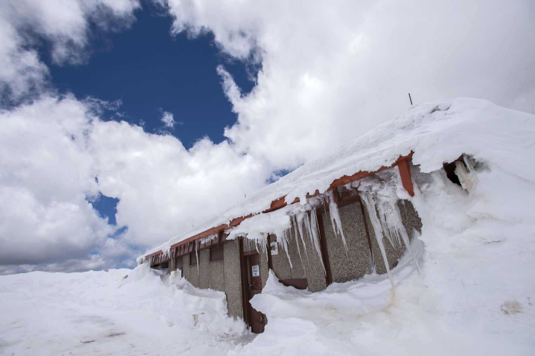Fifteen-foot snow drifts cover the Pikes Peak Summit House Friday, May 29, 2015. The highway is open to mile marker 15, the Double Cut between Glen Cove and Devil's Playground. Under ideal conditions crews hope to have the road open to Devil's Playground early next week and to the 14,115-foot summit in about 10 days, but more snow is in the forecast. (The Gazette, Christian Murdock) (CHRISTIAN MURDOCK, THE GAZETTE)