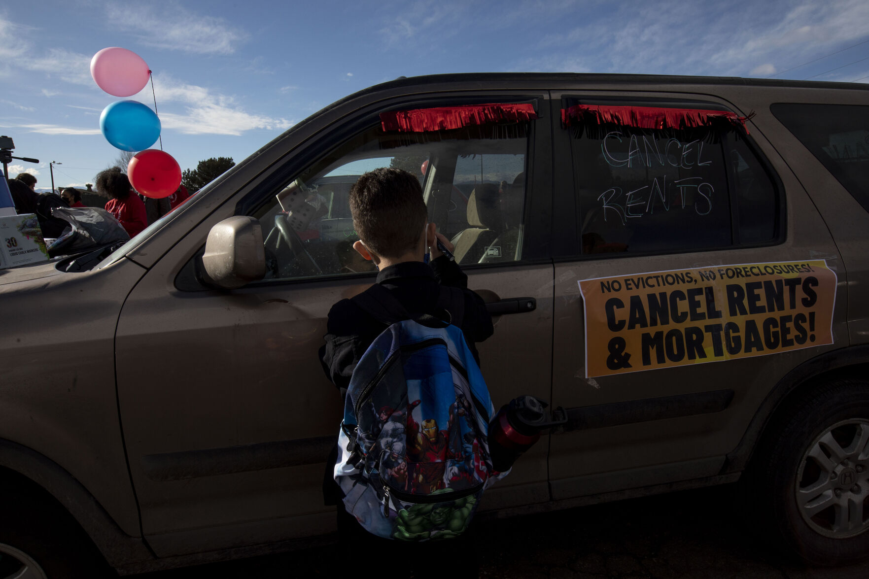 Joshua Clark, 8, helps write on cars in preparation for the Denver chapter of the Party for Socialism and Liberation and 9to5 Colorado holding a ‘Cancel the Rent’ car protest in Denver, Colo., on Saturday, Jan. 30, 2021. The protest was a national day of action with 30 planned for this weekend by PSL chapters in cities around the U.S to ask for government intervention to head off a worsening housing crisis. The concern over eviction moratoriums expiring in April will mean a renewed wave of evictions for residents in Colorado. 