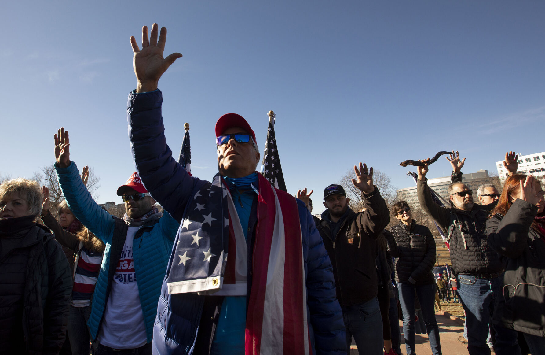 Protesters raise their hands in prayer during the 