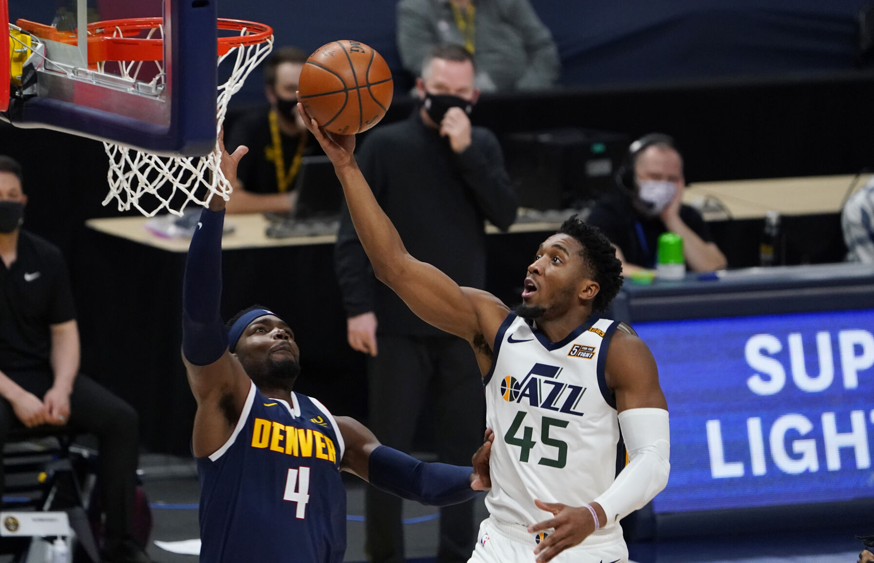 Utah Jazz guard Donovan Mitchell, right, drives to the basket as Denver Nuggets forward Paul Millsap defends in the first half of an NBA basketball game Sunday, Jan. 17, 2021, in Denver. (AP Photo/David Zalubowski) (David Zalubowski)