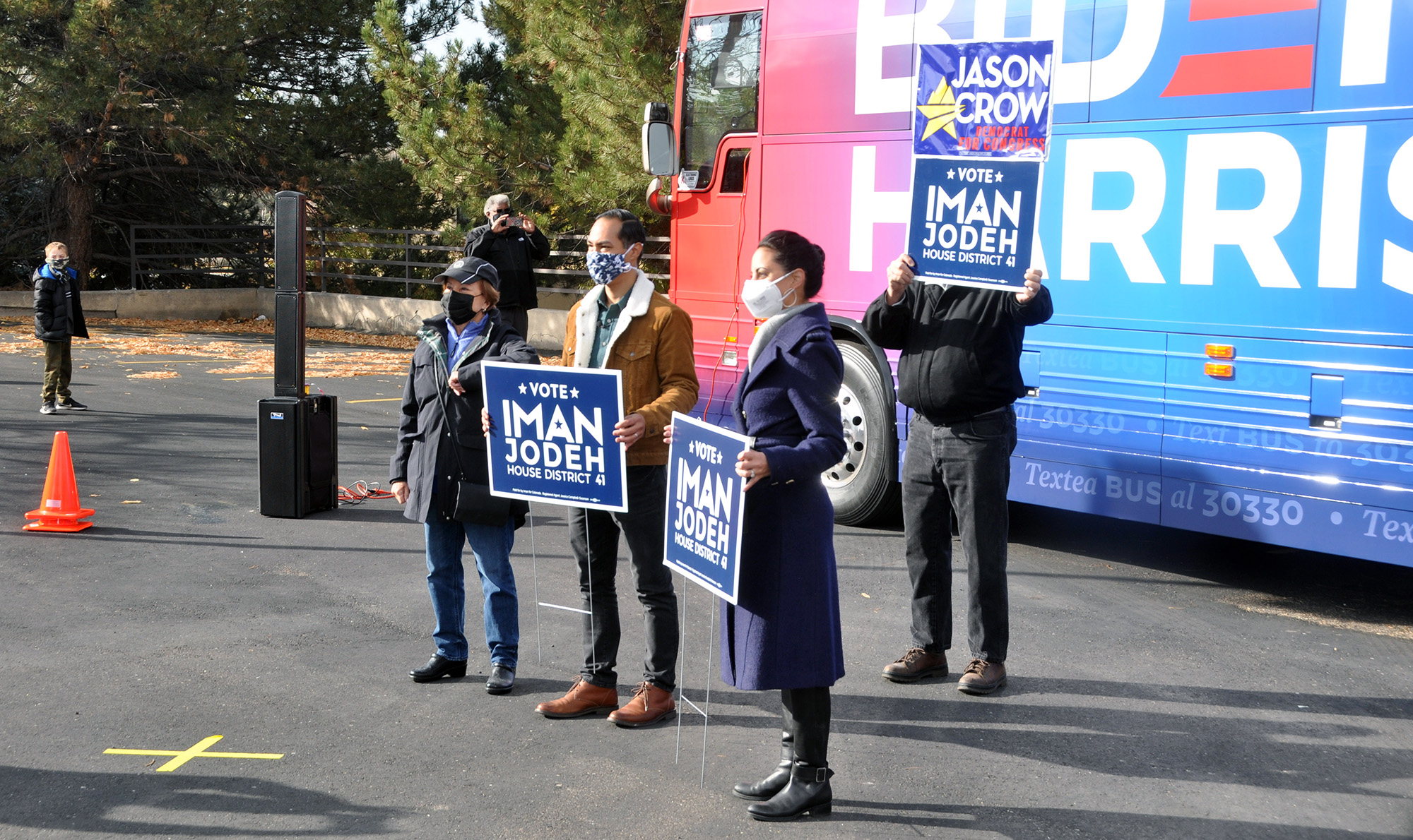 Former Housing and Urban Development Secretary Julian Castro, center, poses for socially distanced photos with Iman Jodeh, the Democratic nominee in House District 41, right, and supporters at a stop on the Biden-Harris campaign's