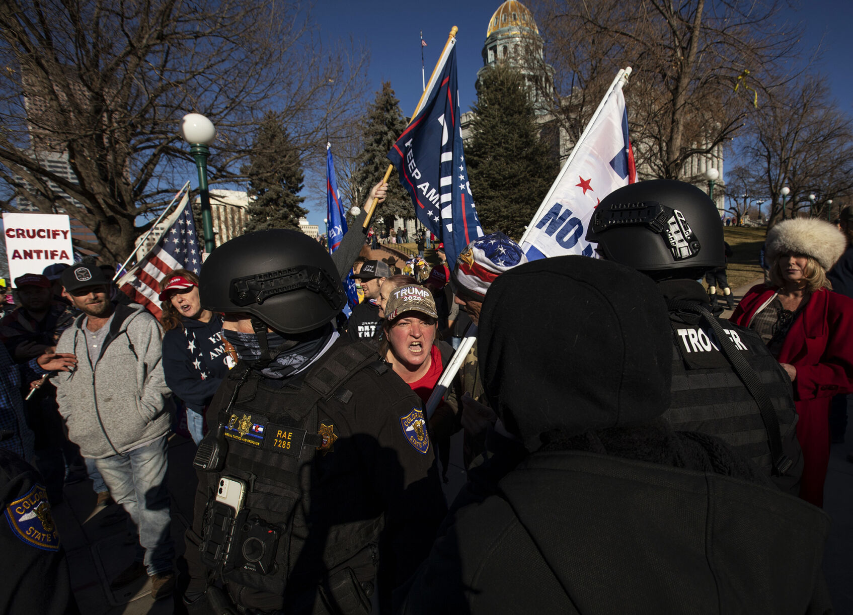 Chelsea Williams, from Castle Rock, yells through an opening between two State Troopers while interacting with a counter-protester during the 