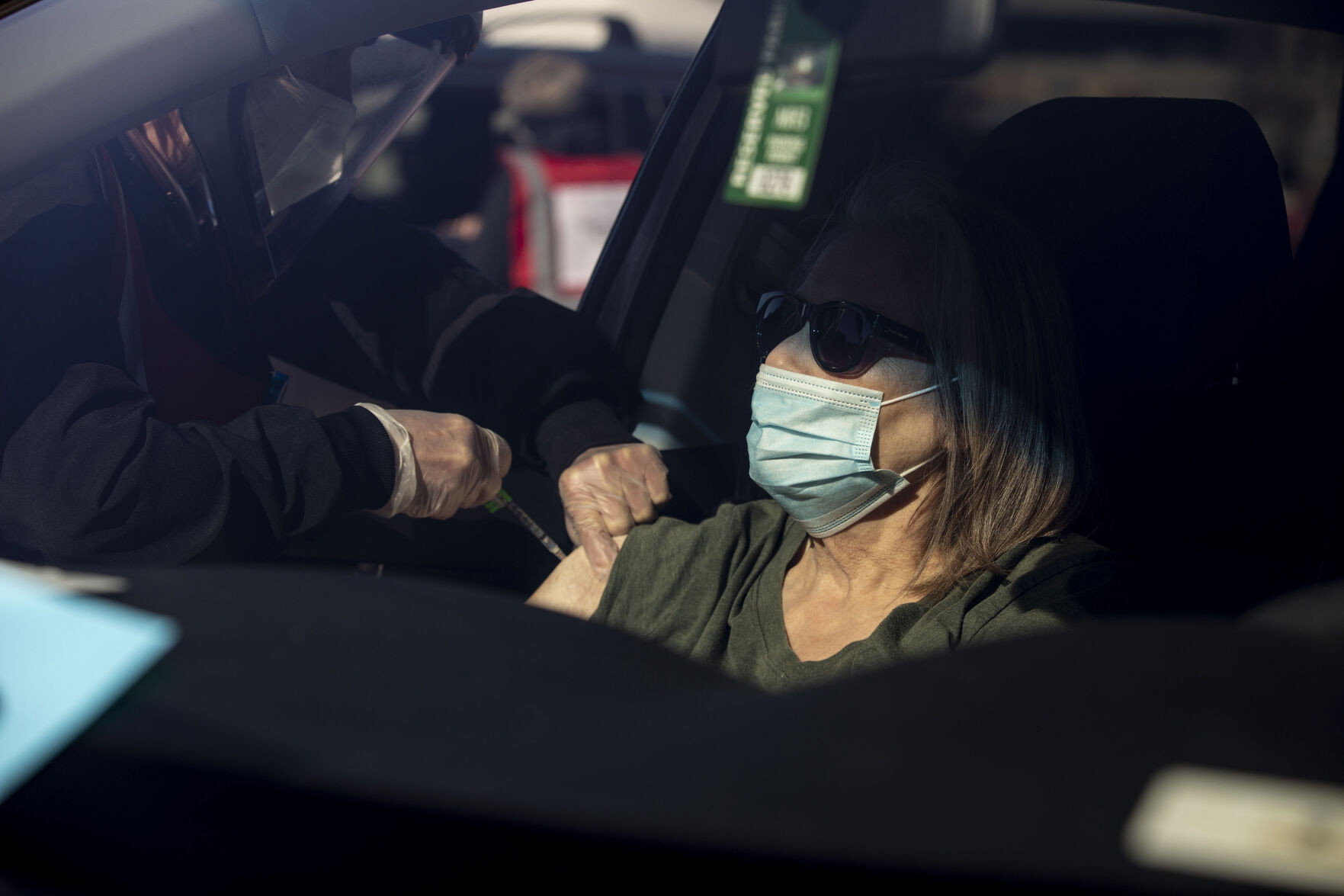 Judith Mackay receives her COVID-19 vaccine administered by UCHealth RN Karen Nerger during UCHealth's large-scale COVID-19 vaccination drive-thru site at the Coors Field parking lot in Denver Colo., on Saturday, Jan. 30, 2021. The vaccination site is the largest in the state with 10,000 older people expected to be vaccinated through the weekend. (Chancey Bush/ The Gazette) (Chancey Bush/ The Gazette)