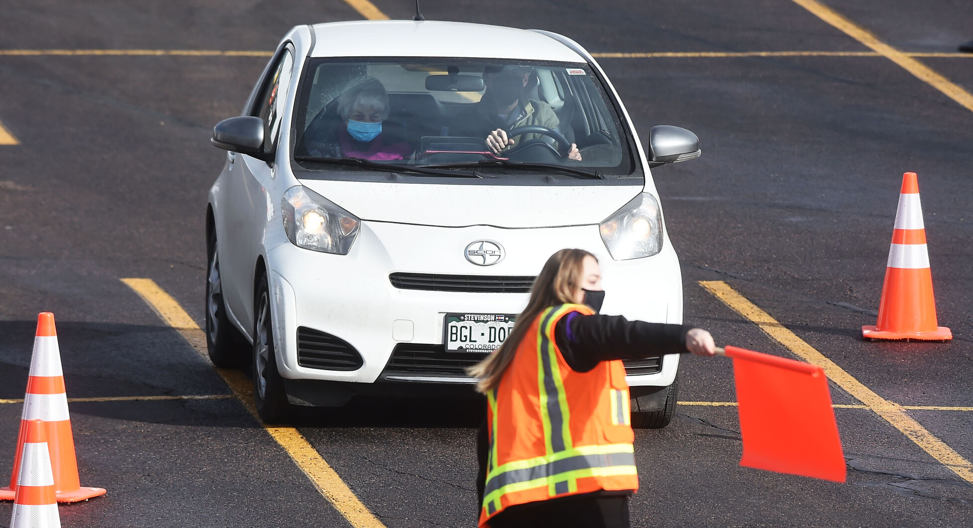 During a test run for giving mass vaccinations, a couple is directed to a station where they will receive their shots while still in their car on Sunday, Jan. 24, 2021. About 1000 Seniors received their vaccines that day in the parking lot of Coors Field. UCHealth hopes to give about 10,000 vaccinations this weekend at the same location. (Photo by Jerilee Bennett, The Gazette) (JERILEE BENNETT)