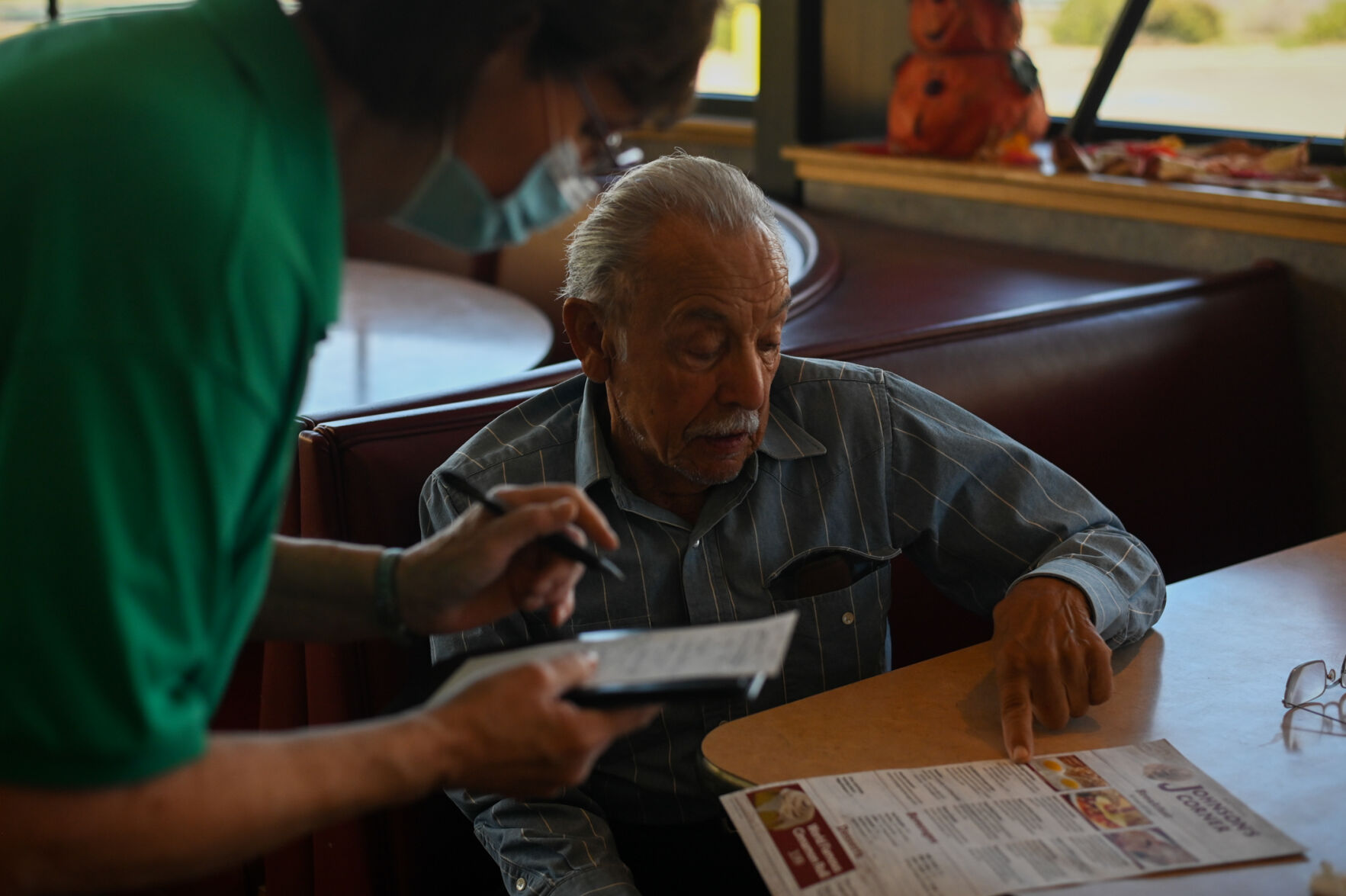 Maria Mendoza serves Jose Martin del Campo, a regular at Johnson’s Corner for six decades. Mendoza has been a server at Johnson’s Corner, a truck stop off Interstate 25, since the 1990s. (photos by Skyler Ballard, The Gazette)