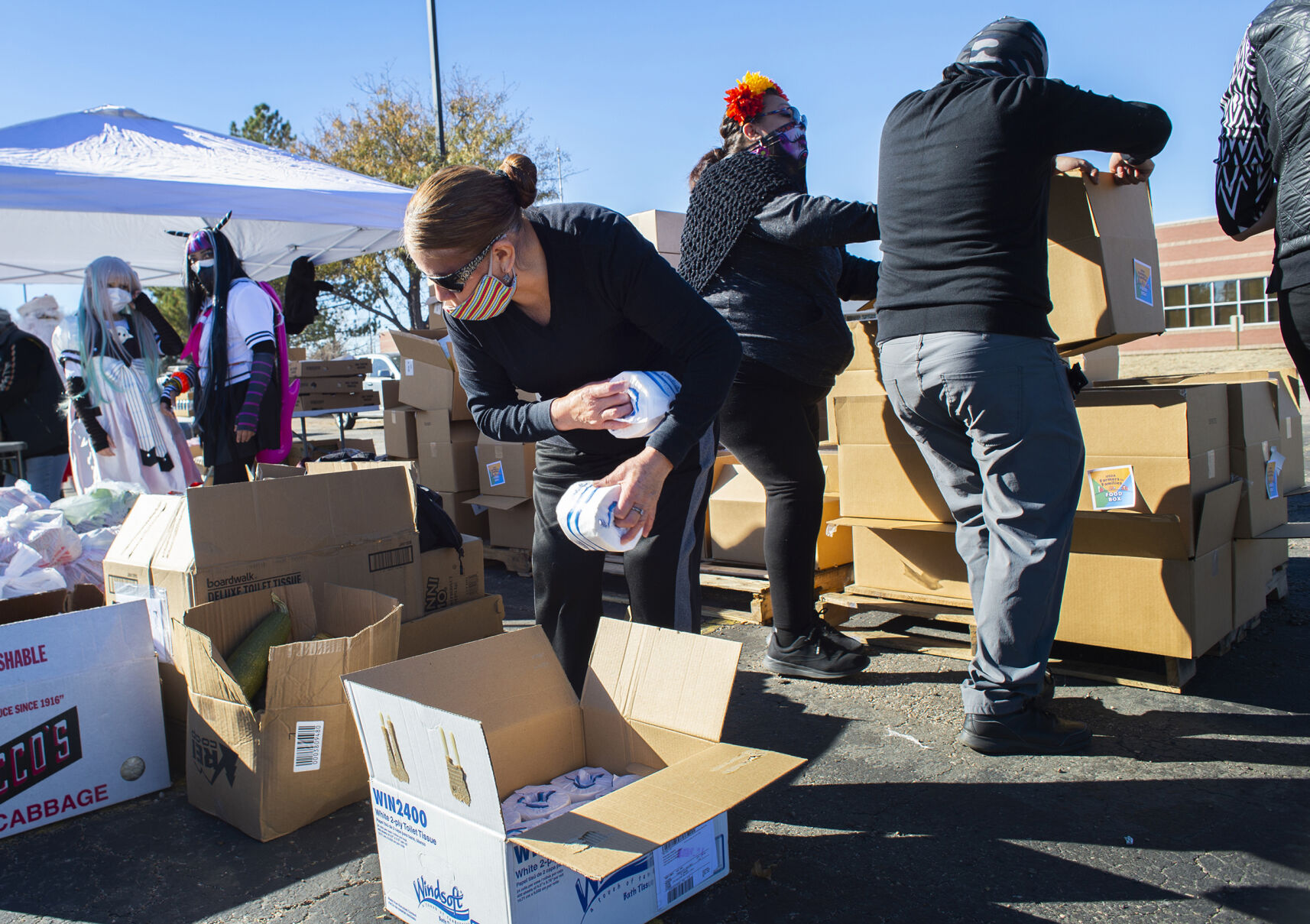 Mercedes Jara and other volunteers fill food baskets for neighbors at the Wonderbound Campus on E 40th Avenue Friday, Oct. 30, 2020, in the Globeville neighborhood of Denver. Volunteers deliver the food to residents in the Globeville and Elyria-Swansea areas every Friday. We Don’t Waste and other non-profit organizations served more than 500 cars during a drive-thru food bank the same day. (The Gazette, Christian Murdock) (Christian Murdock/The Gazette)