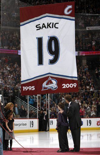 Joe Sakic, right, looks on during a ceremony to mark his retirement from the Colorado Avalanche before the team’s home opener of the NHL season against the San Jose Sharks in Denver on Thursday, Oct. 1, 2009. (AP Photo/David Zalubowski) (David Zalubowski)