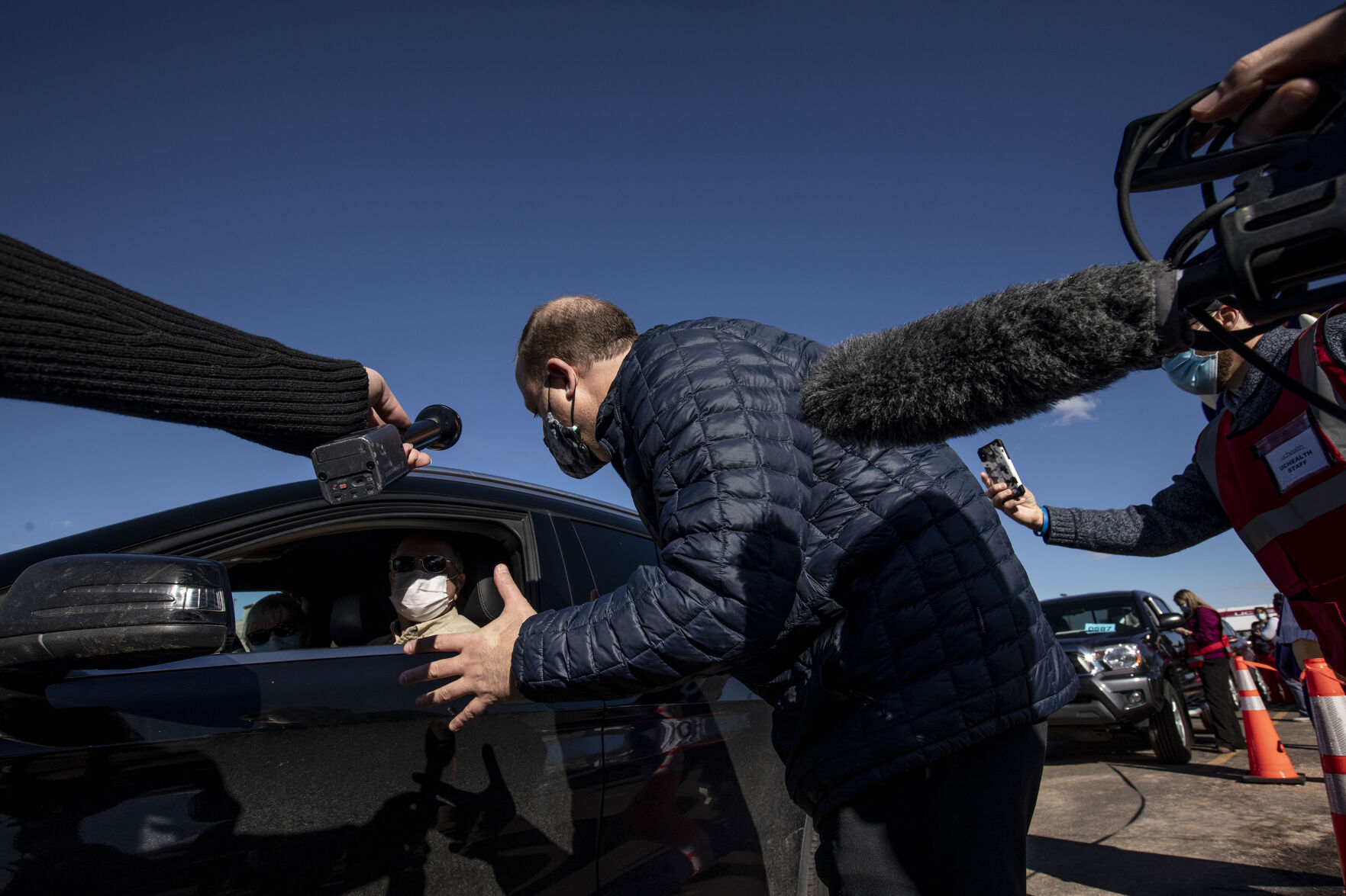 Gov. Jared Polis talks with seniors who received their vaccinations during UCHealth's large-scale COVID-19 vaccination drive-thru site at the Coors Field parking lot in Denver Colo., on Saturday, Jan. 30, 2021. The vaccination site is the largest in the state with 10,000 seniors expected to be vaccinated through the weekend. (Chancey Bush/ The Gazette) (Chancey Bush/ The Gazette)