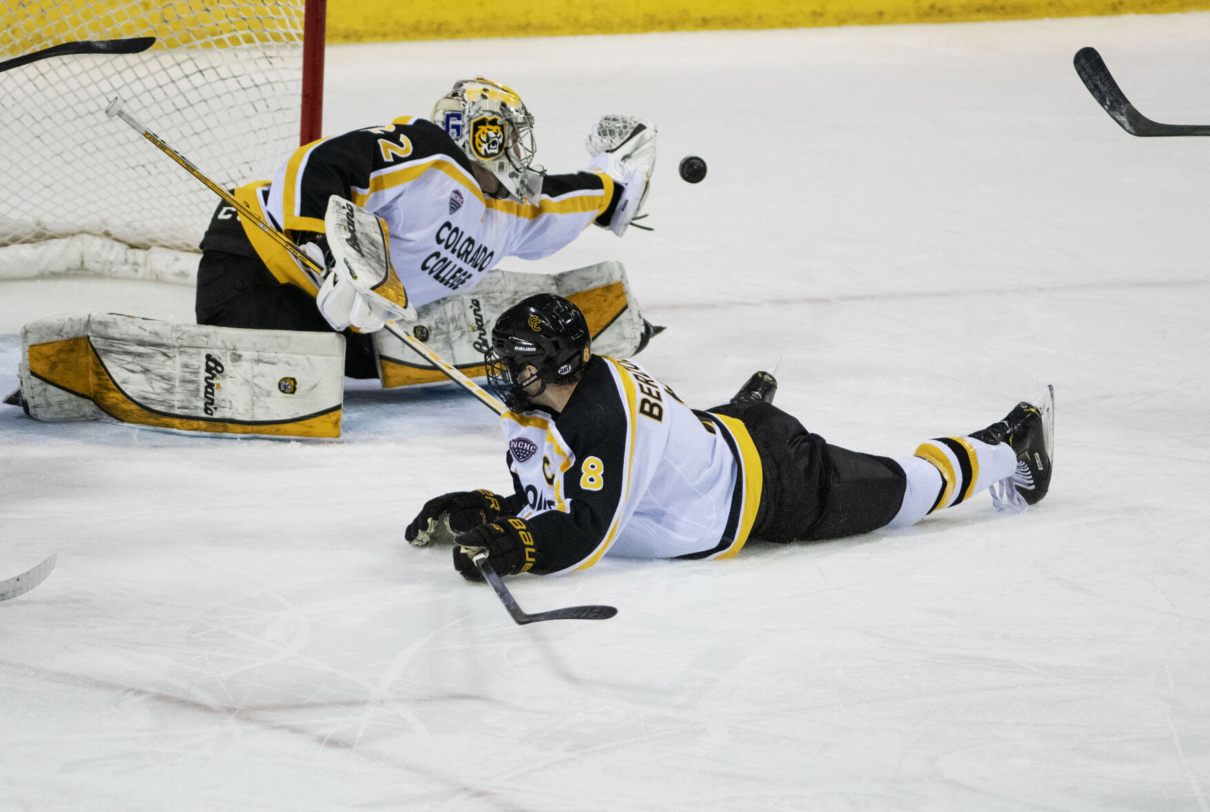 Colorado College freshman goalie Dominic Basse (22) reaches for the puck during college hockey game as the CC Tigers and DU Battle for the Gold Pan at The Broadmoor World Arena in Colorado Springs on Thursday, Feb. 25, 2021. Denver won the game against the CC Tigers by a score of 5 to 1. (Chancey Bush/ The Gazette) (Chancey Bush/ The Gazette)