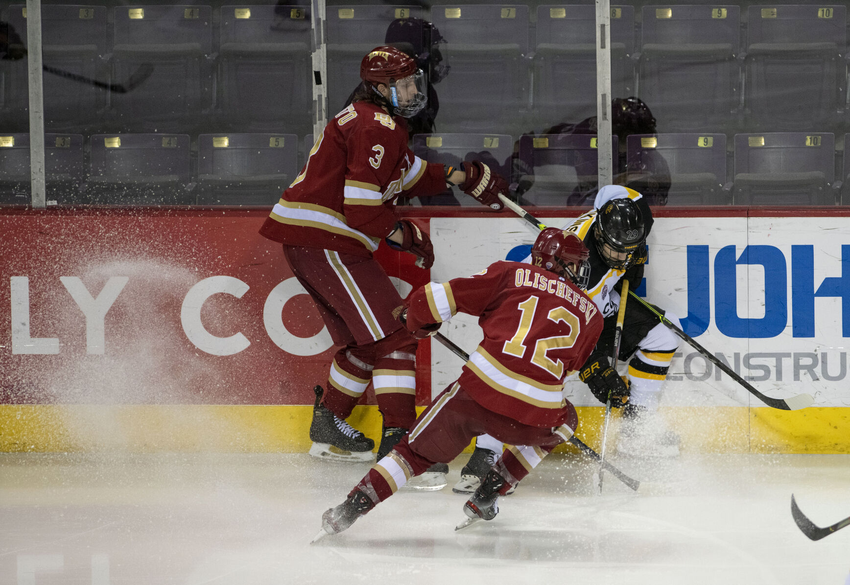 Colorado College junior forward Brian Hawkinson (29) gains possession of the puck as Denver senior forward Kohen Olischefski (12) closes in as they Battle for the Gold Pan at The Broadmoor World Arena in Colorado Springs on Thursday, Feb. 25, 2021. Denver won the game against the CC Tigers by a score of 5 to 1. (Chancey Bush/ The Gazette) (Chancey Bush/ The Gazette)