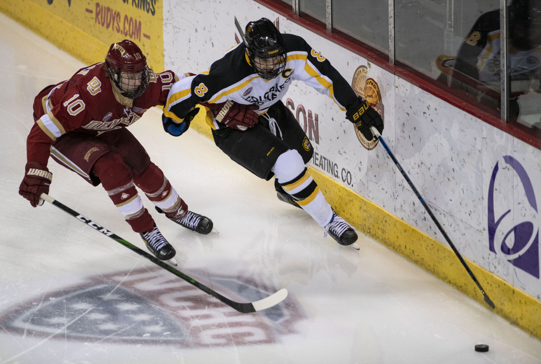 Denver senior forward Jaakko Heikkinen (10) and Colorado College senior defenseman Zach Berzolla (8) race towards the puck during college hockey game as the CC Tigers and DU Battle for the Gold Pan at The Broadmoor World Arena in Colorado Springs on Thursday, Feb. 25, 2021. Denver won the game against the CC Tigers by a score of 5 to 1. (Chancey Bush/ The Gazette) (Chancey Bush/ The Gazette)