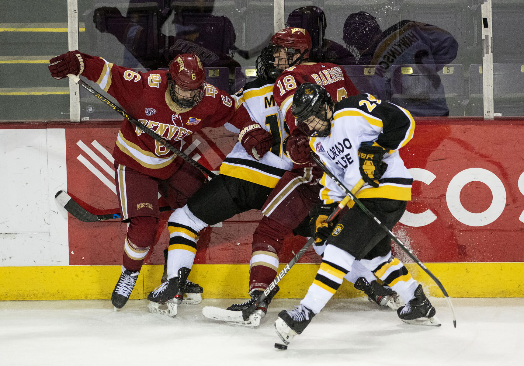 Denver freshman forward McKade Webster (6) and senior forward Ryan Barrow (18) slam against the glass battling for the puck with Colorado College Tigers as they Battle for the Gold Pan at The Broadmoor World Arena in Colorado Springs on Thursday, Feb. 25, 2021. Denver won the game against the CC Tigers by a score of 5 to 1. (Chancey Bush/ The Gazette) (Chancey Bush/ The Gazette)