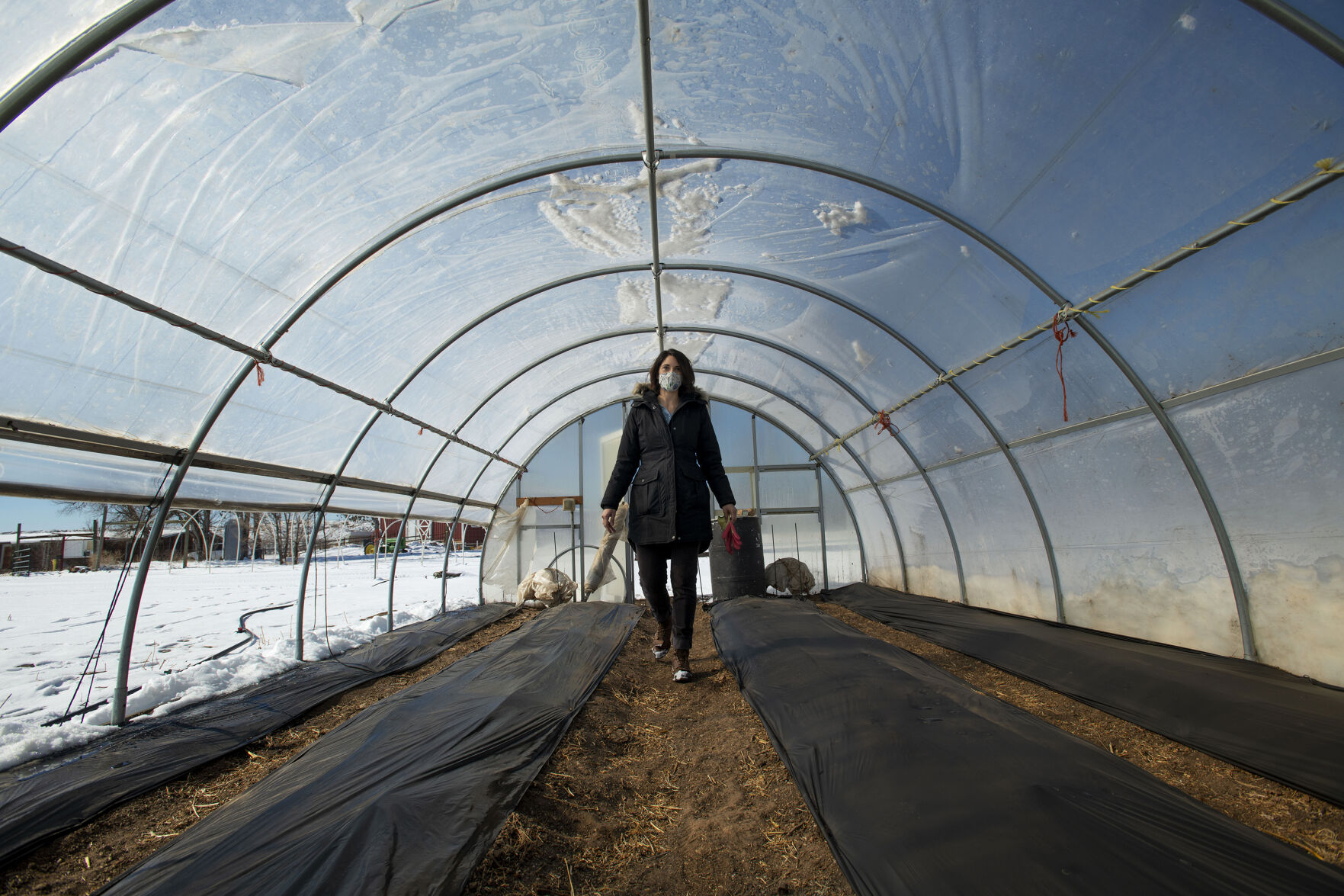 Nikki McComsey, owner of Gather Mountain Blooms, walks through a green house that will be home to a portion of her flower farm at Venetucci Farm in Security on Friday, Feb. 26, 2021. McComsey is leasing land from the farm to grow a variety of flowers and will be managing the property for weddings and events, including the Fall Festival. Contamination of the Widefield aquifer, which was saturated with perfluorinated compounds originating from Peterson Air Force base firefighting foam, forced the farm to stop selling edible goods in 2016. (Chancey Bush/ The Gazette) (Chancey Bush/ The Gazette)