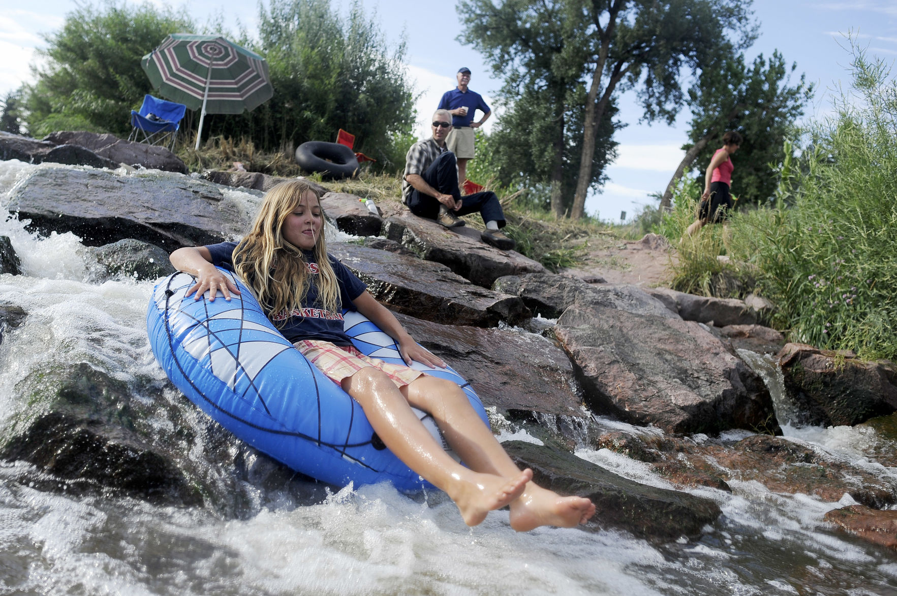 Jade Loerzel, 12, tubes down a waterfall near Monument Valley Park Tuesday, July 23, 2013 during the first Fountain Creek Watershed Greenway Fund Splash Event. (The Gazette File)