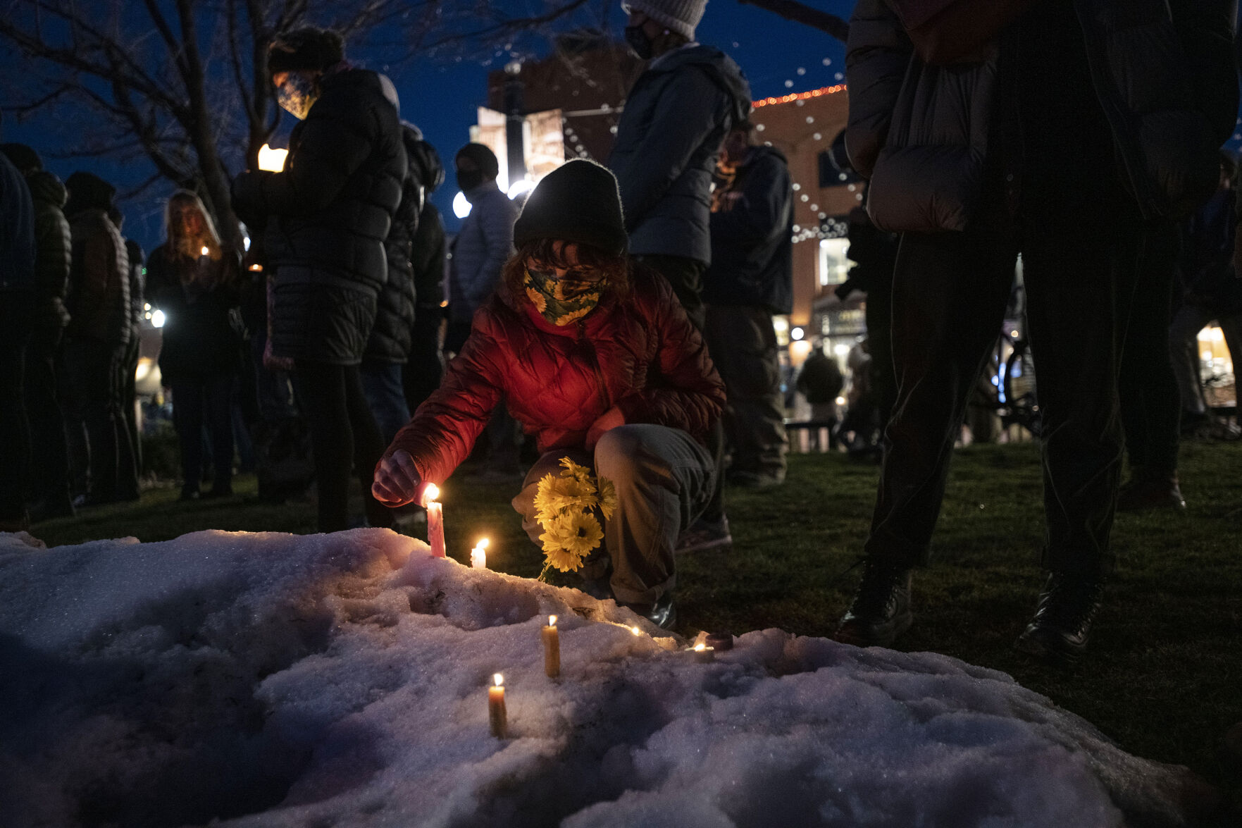 Mattie Horn lights a candle during a candlelight vigil that was held to mourn the loss of 10 people including a police officer who were killed in a mass shooting at King Soopers supermarket on Monday, outside the courthouse in Boulder, Colo., on Wednesday, March 24, 2021. (Chancey Bush/ The Gazette) (Chancey Bush)