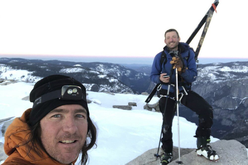 In this photo provided by Jason Torlano, he poses with his friend, Zach Milligan, right, on Half Dome in Yosemite National Park, Calif., on Sunday, Feb. 21, 2021. Two men climbed some 4,000 feet to the top of Yosemite's Half Dome in subfreezing temperatures and skied down the famously steep monolith to the valley floor. Torlano, 45, and Milligan, 40, completed the daring descent in five hours on Sunday by charging down Half Dome's arching back and using ropes to rappel down several sections of bare rock known as the 