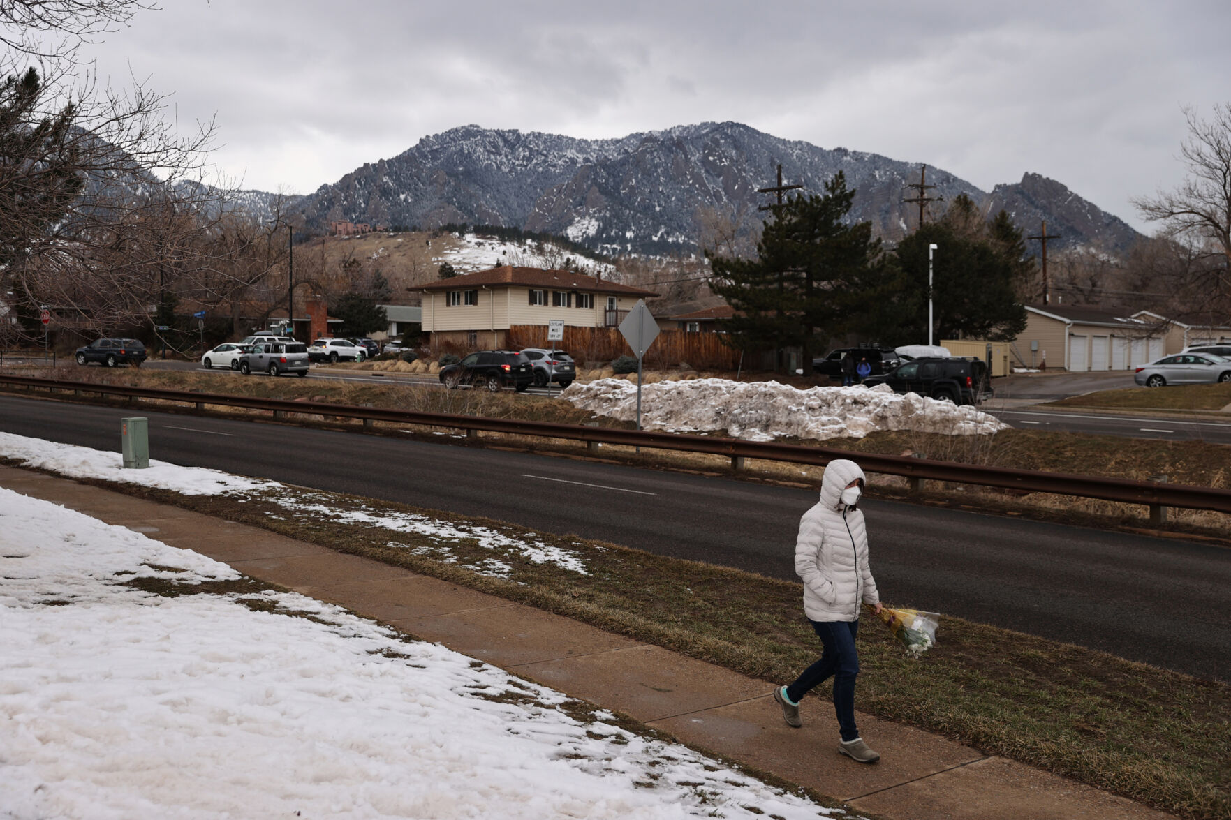 A community member with a flower bouquet walks toward the King Soopers on Table Mesa Drive in Boulder on March 23, 2021. A gunman killed 10 people in a mass shooting at the store the day before. (Forrest Czarnecki/The Gazette) (Forrest Czarnecki)